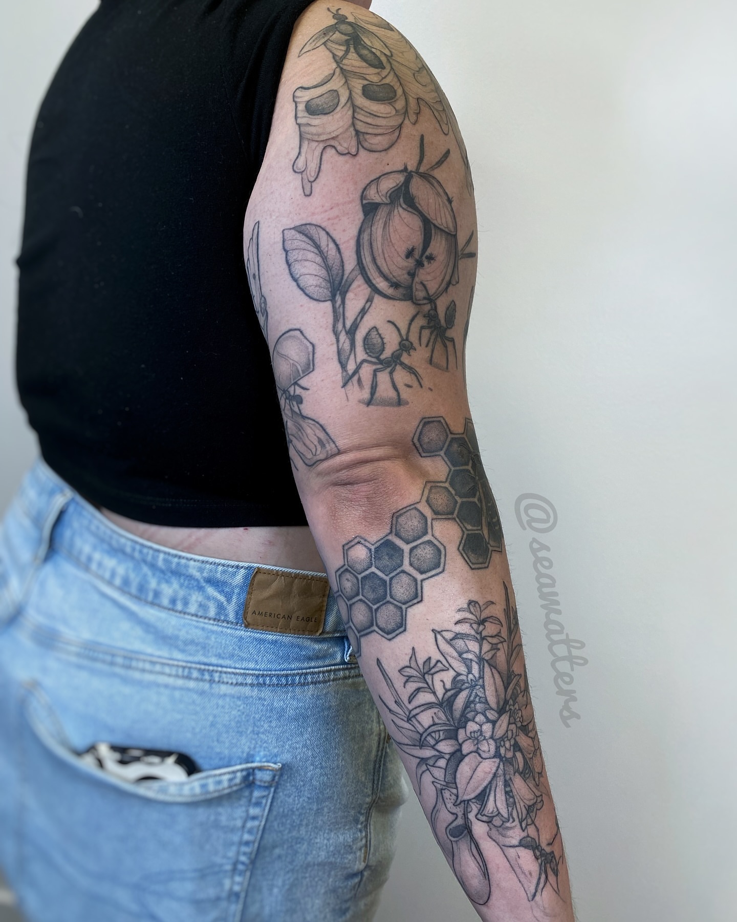 Bee hive and floral geometric tattoo on the forearm by Caitlin Watters