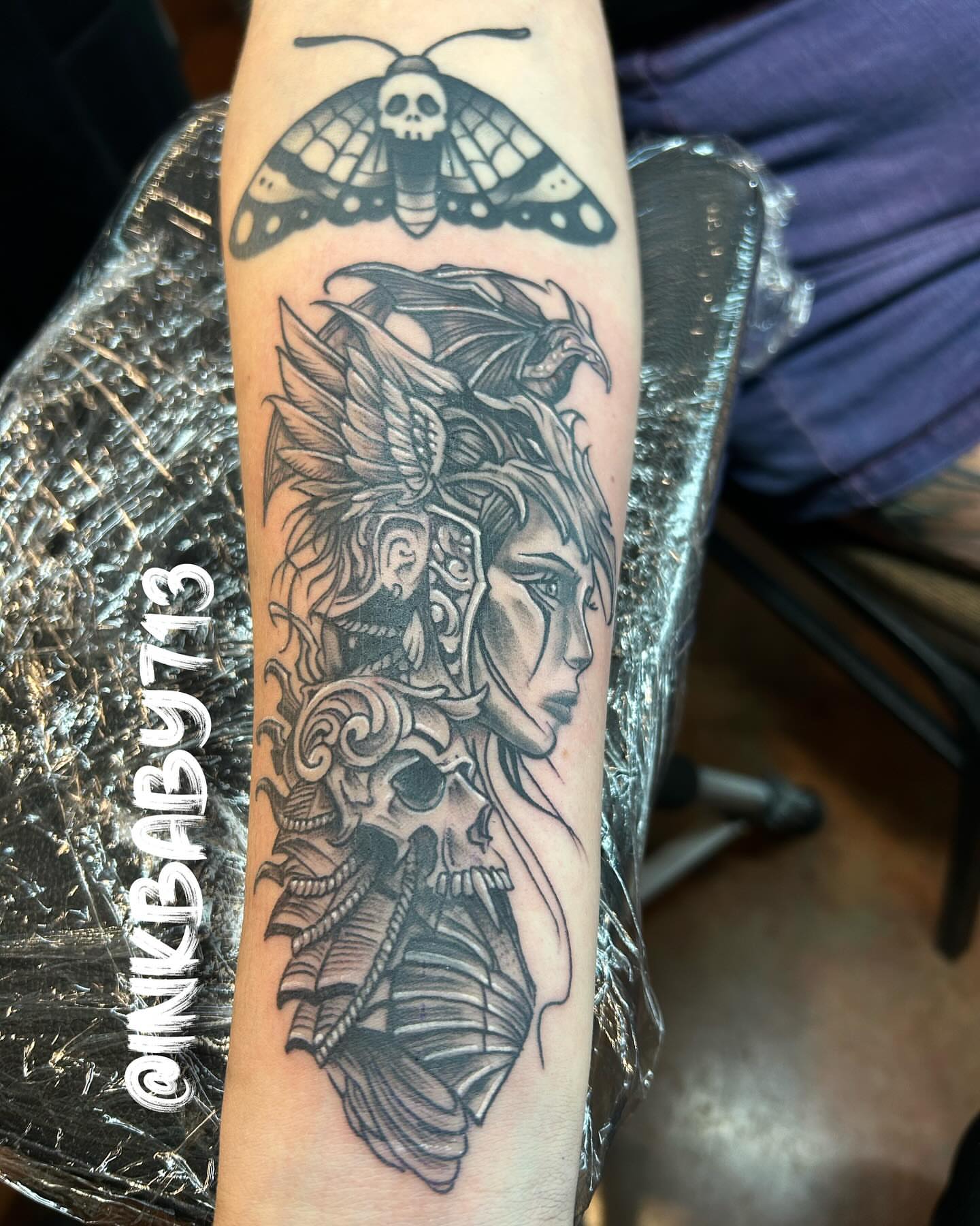 Woman with dragon realism tattoo on the forearm by Ayanna Luna