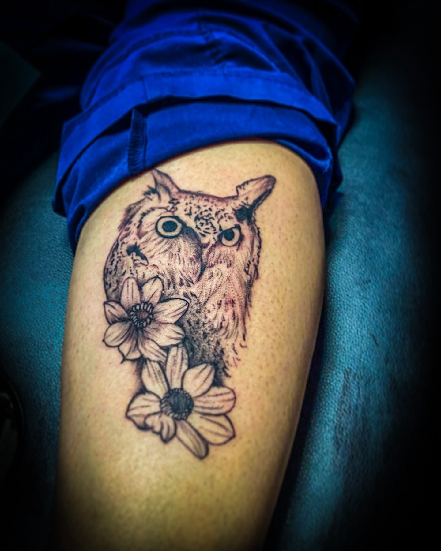 Owl and flowers realism tattoo on the thigh by Rico Rosario