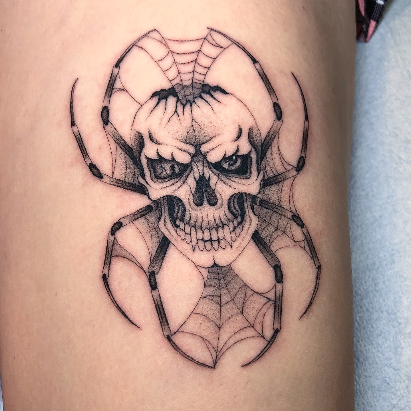 Skull dotwork tattoo on the thigh by Mickey