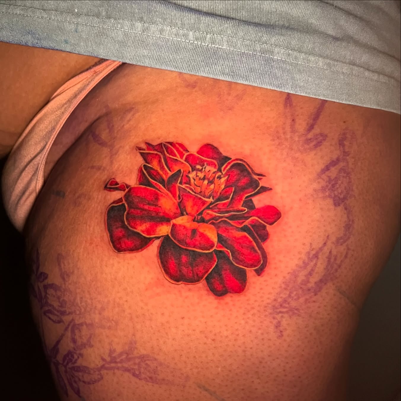 Red flower realism tattoo on the thigh by Irina Shapiro, Somerville, Massachusetts