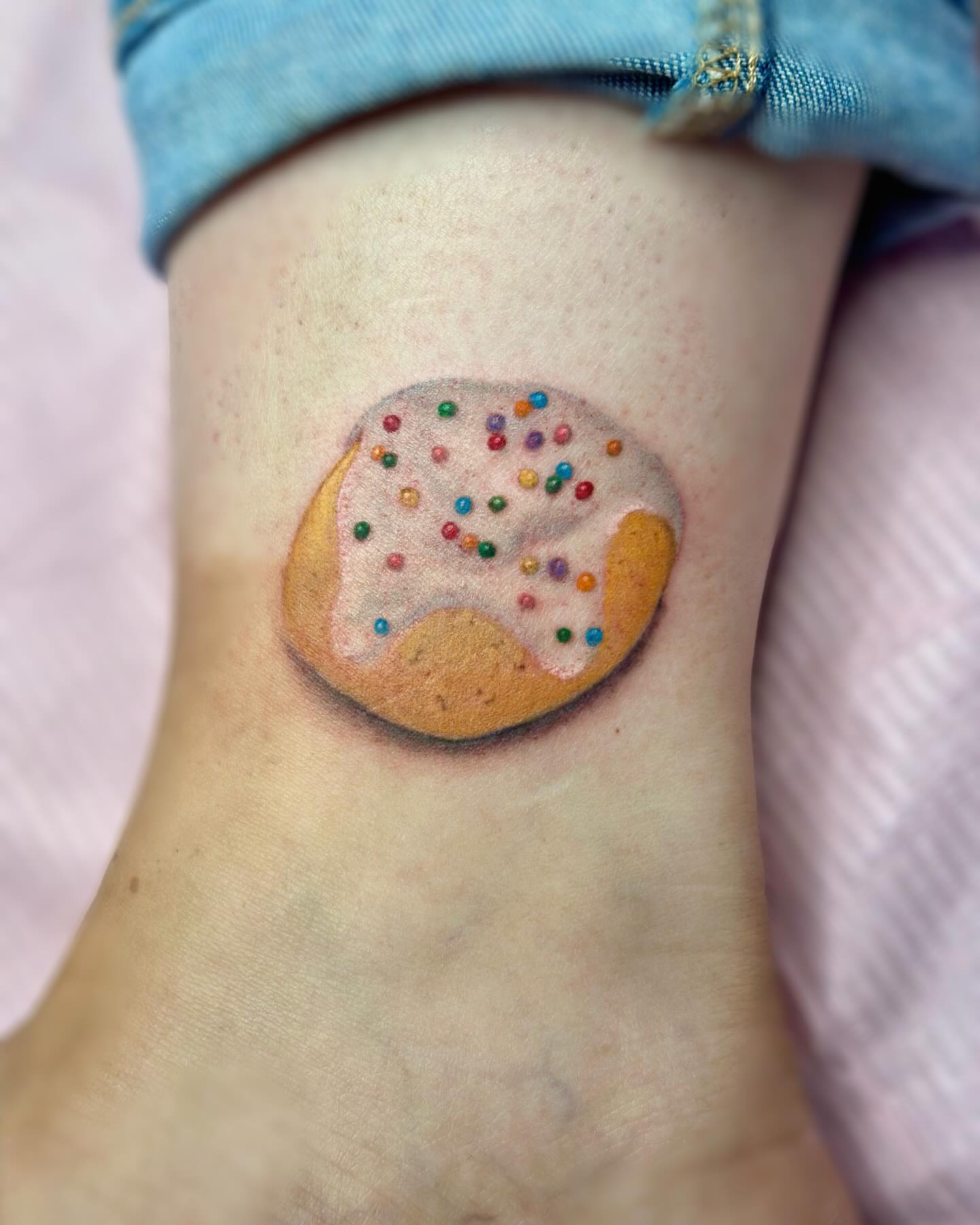 Donut realism tattoo on the foot by Jakki Hicks