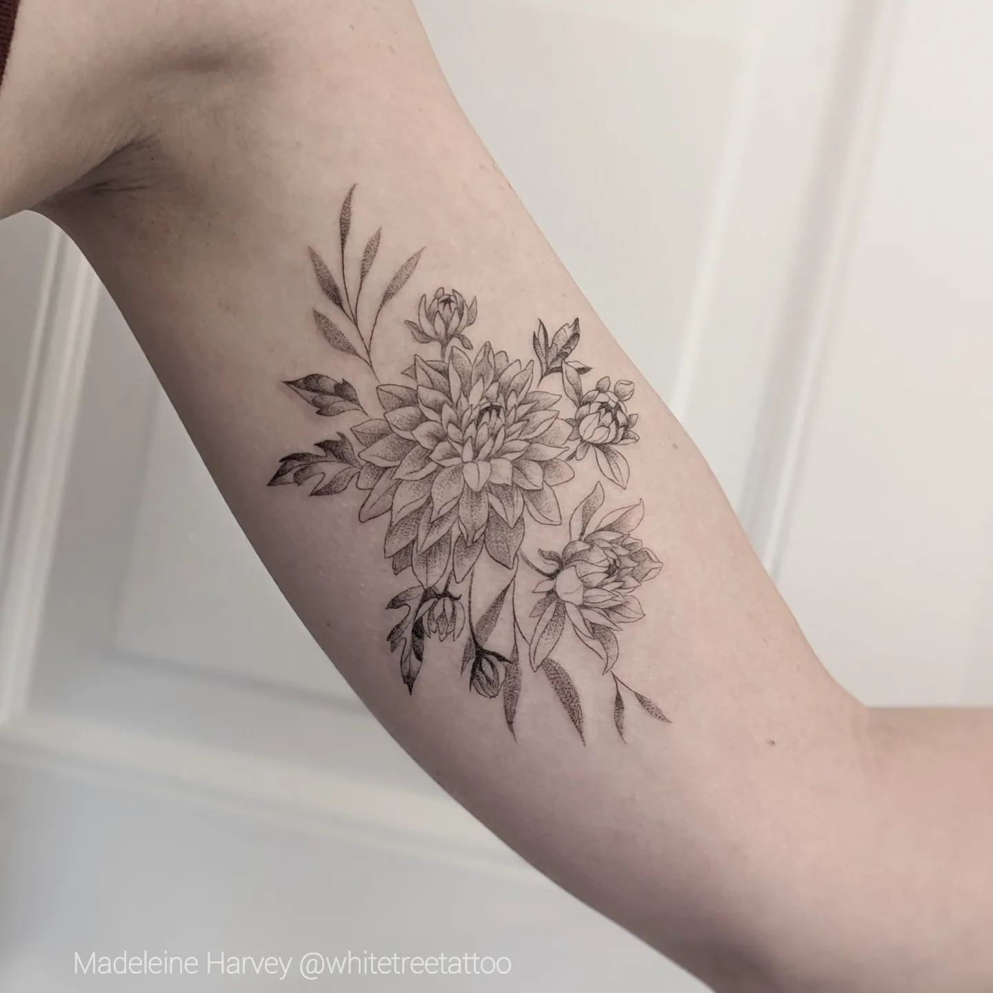 Floral bouquet black and grey tattoo on the forearm by Maddie