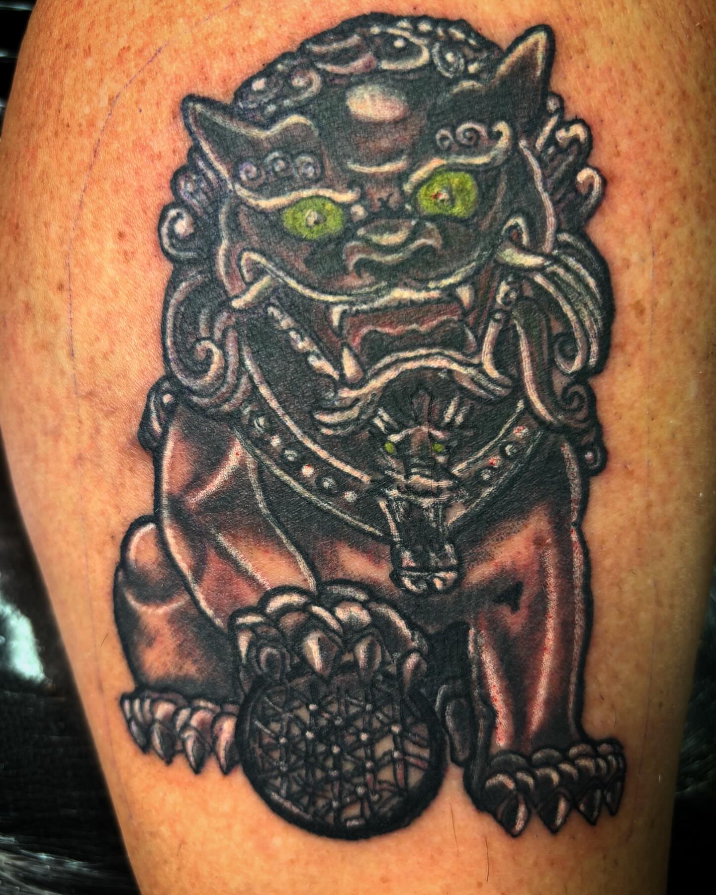 Lion statue black and grey tattoo on the thigh by Bobby Glennon