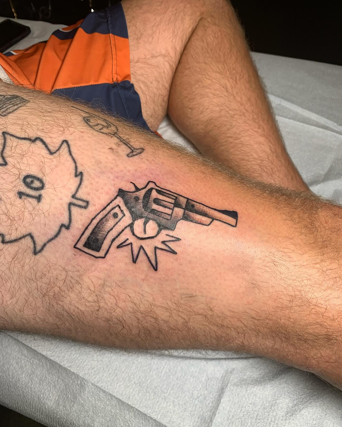 Revolver and bullet black and grey tattoo on the forearm by Nolan Croteau