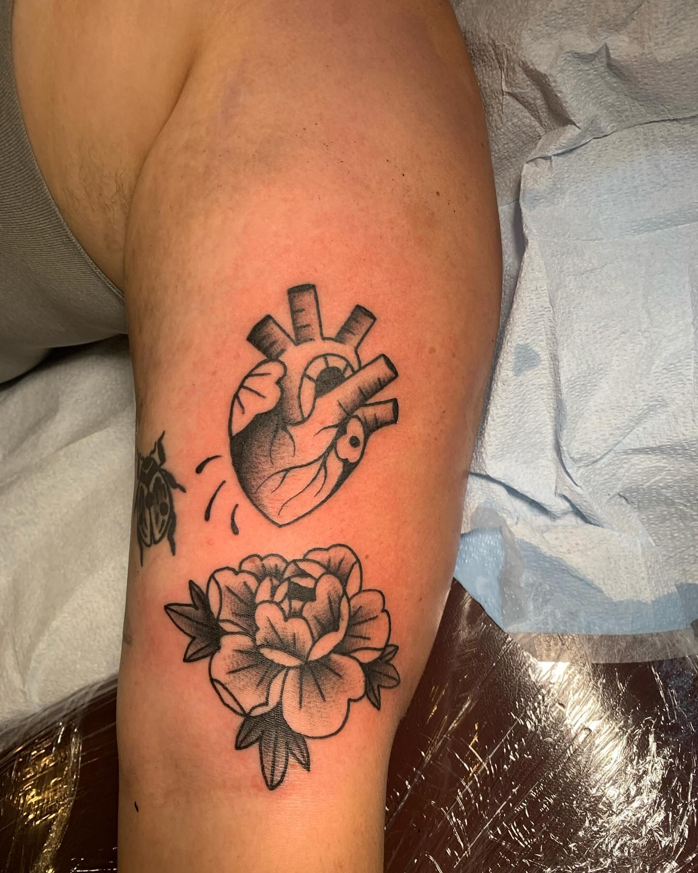 Heart and flower black and grey tattoo on the forearm by Nolan Croteau