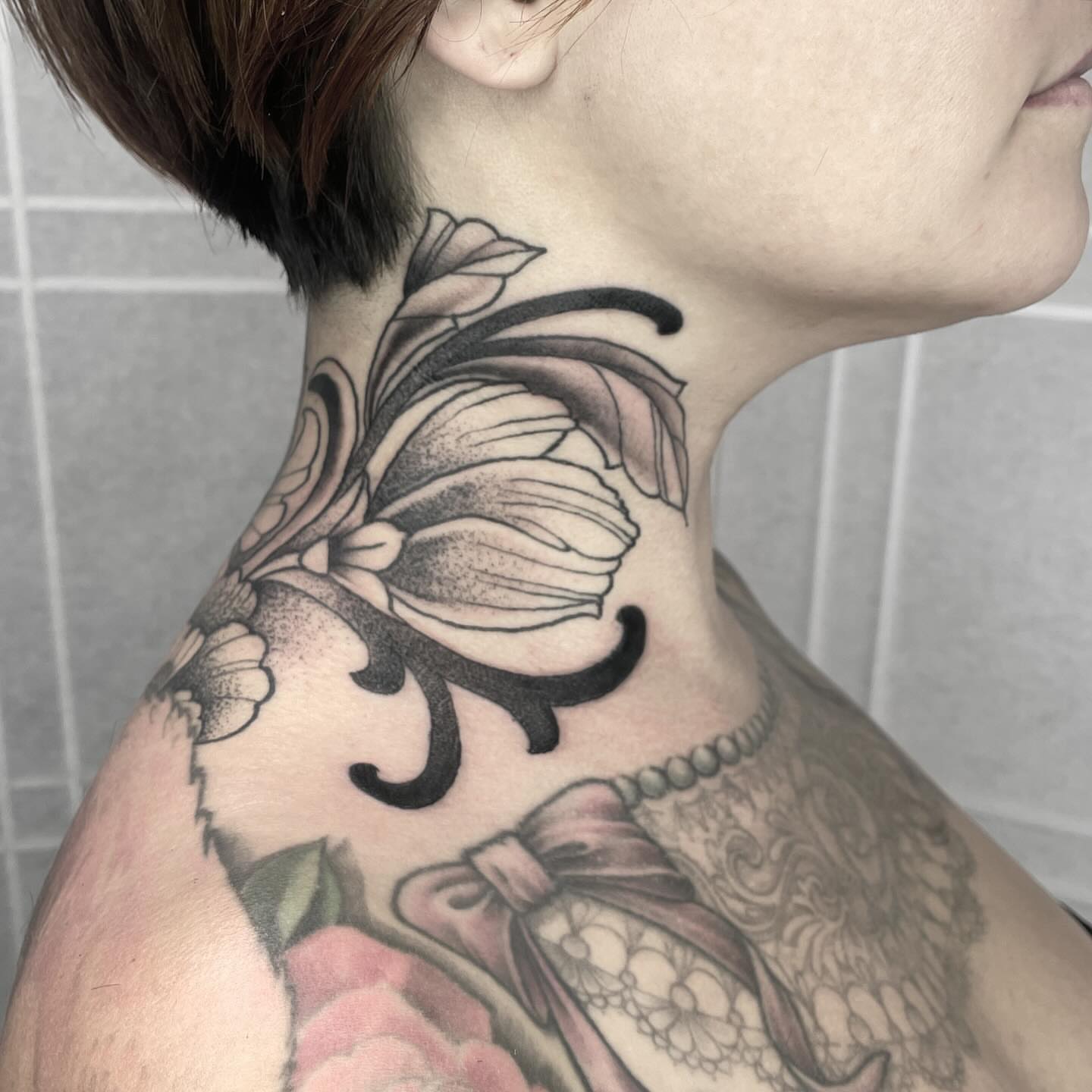 Flower and bow black and grey tattoo on the neck by Amanda Marie, Edmonds, Washington