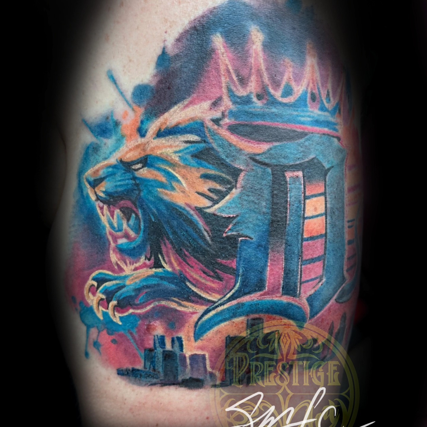 Lion with crown watercolor tattoo on the forearm by Shawn Cook