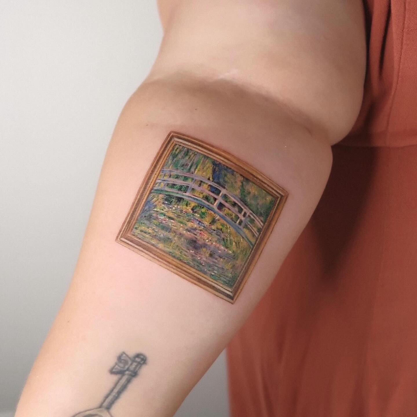 Bridge and garden realism tattoo on the forearm by Alissa Jung