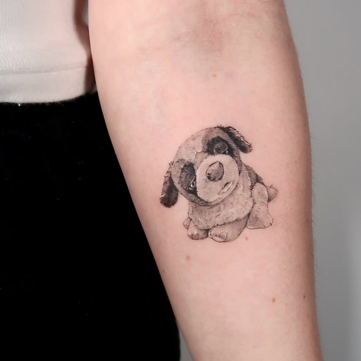 Puppy black and grey tattoo on the forearm by Alissa Jung