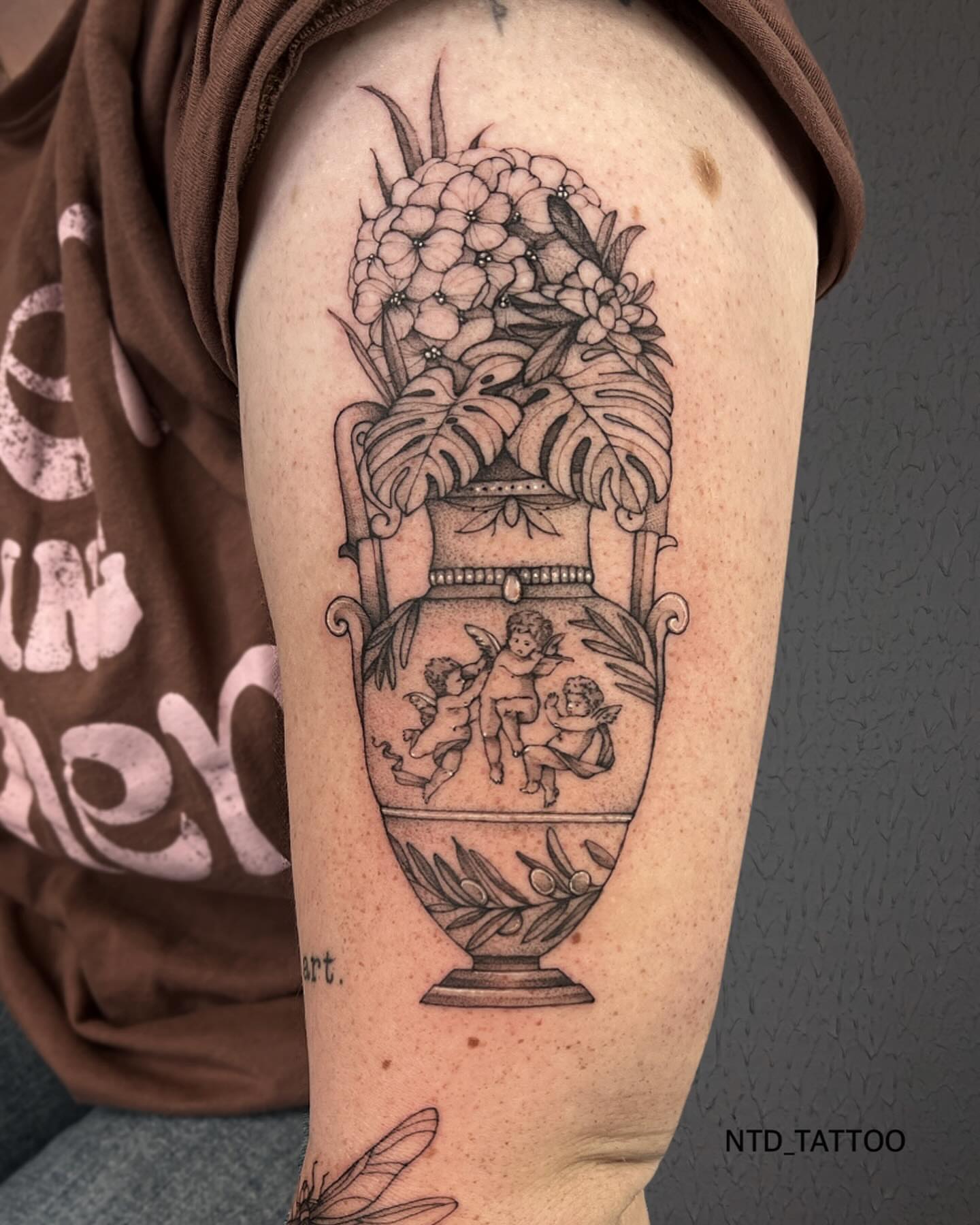 Urn with cherubs and flowers black and grey tattoo on the forearm by Tetiana Maxon