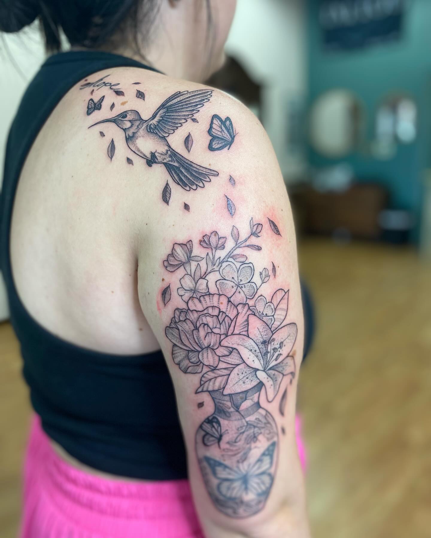 Hummingbird and floral bouquet realism tattoo on the shoulder by Taya Lynn, Hudson, Wisconsin