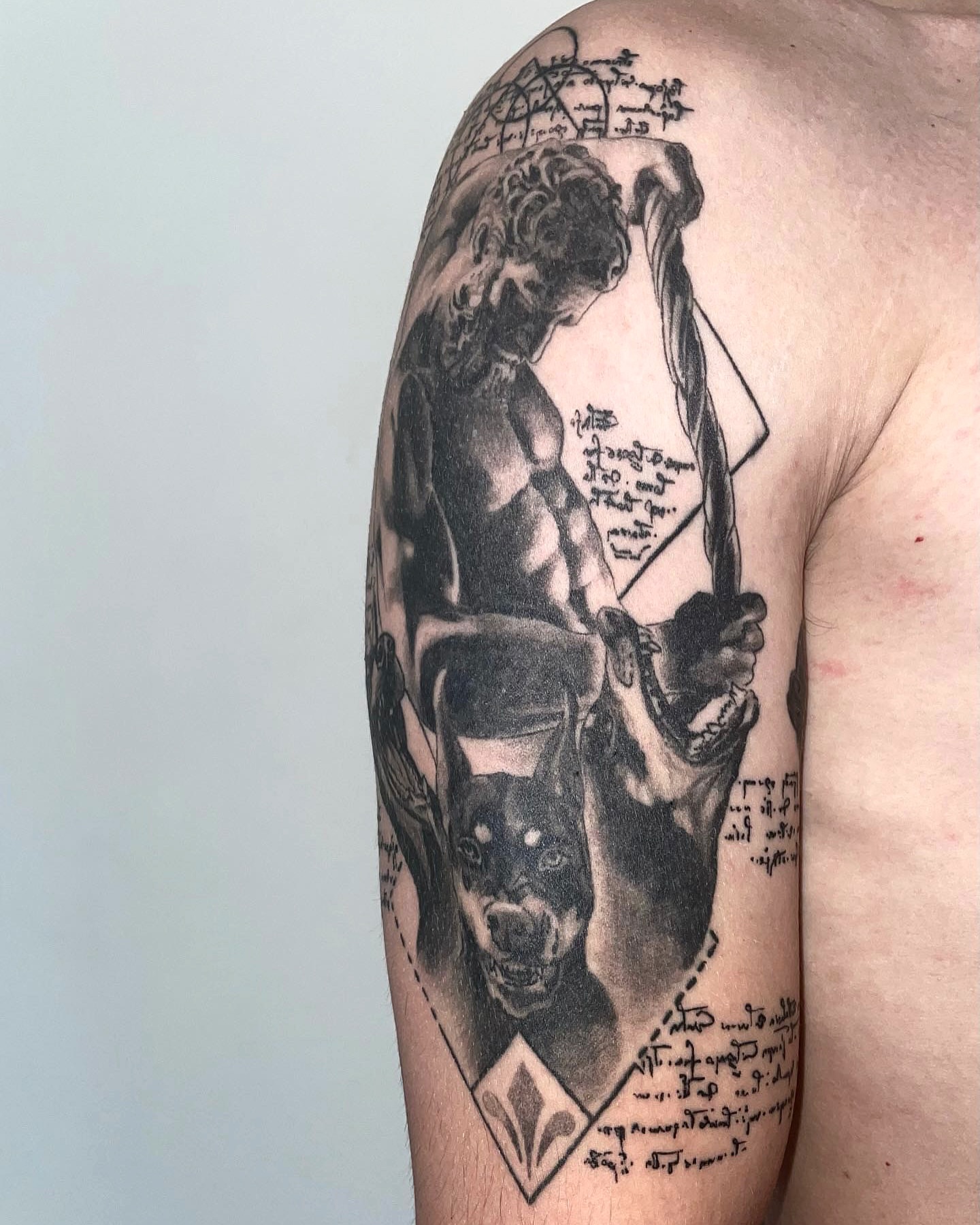 Mythical figure with dog realism tattoo on the upper arm by Ben Cisek