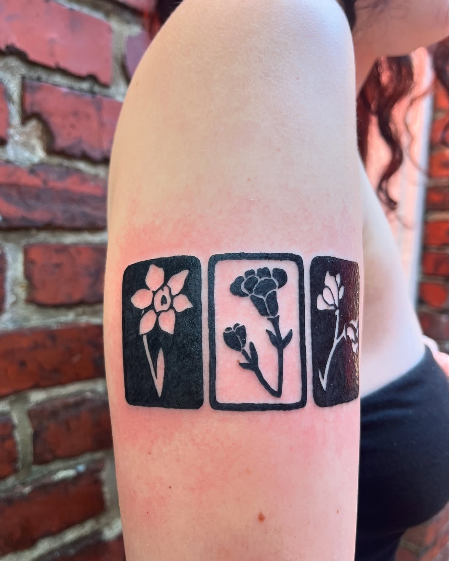 Floral arrangement black and grey tattoo on the forearm by layne