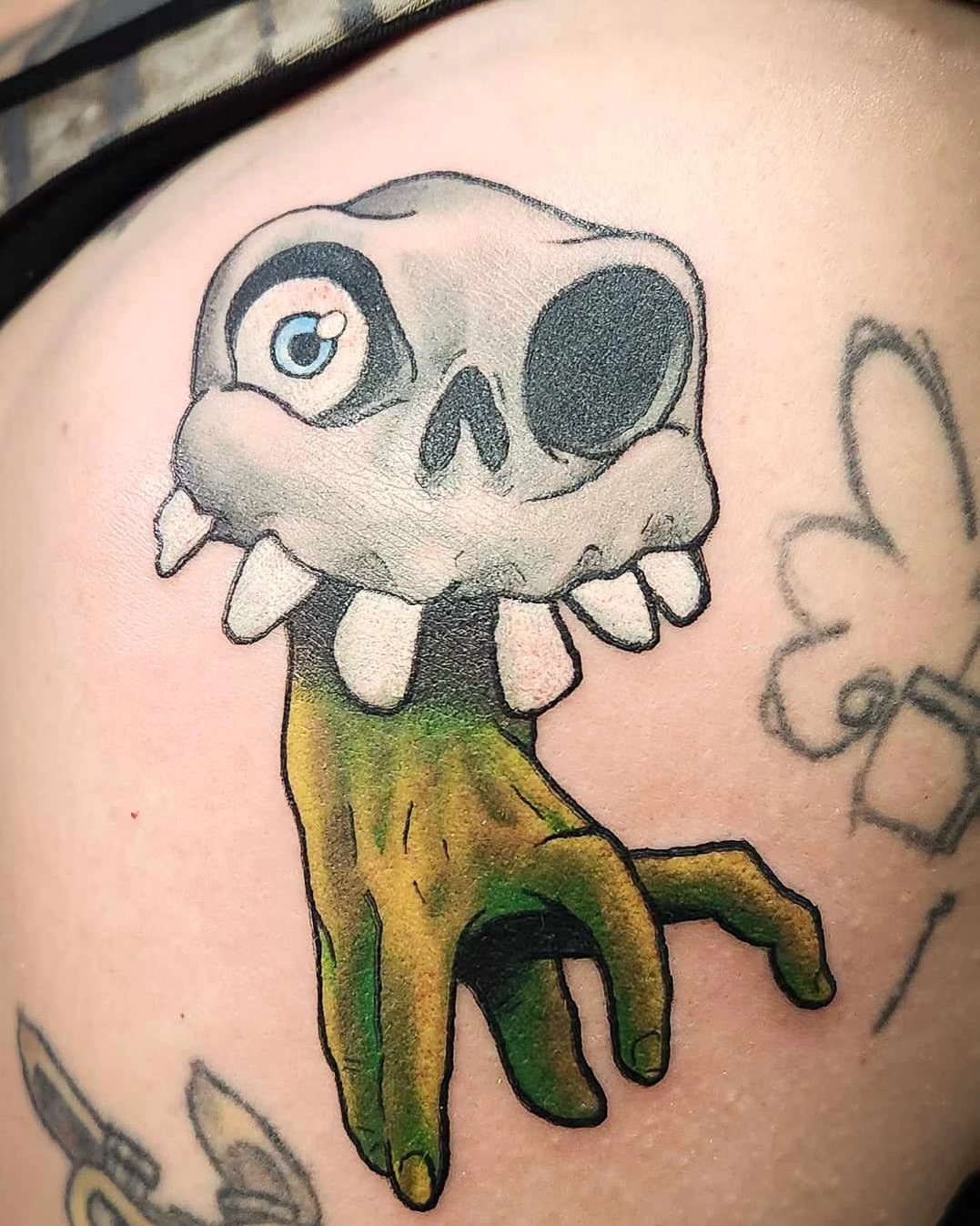 Skull hand American traditional tattoo on the shoulder by Samantha Von Zombia, Saint Paul, Minnesota