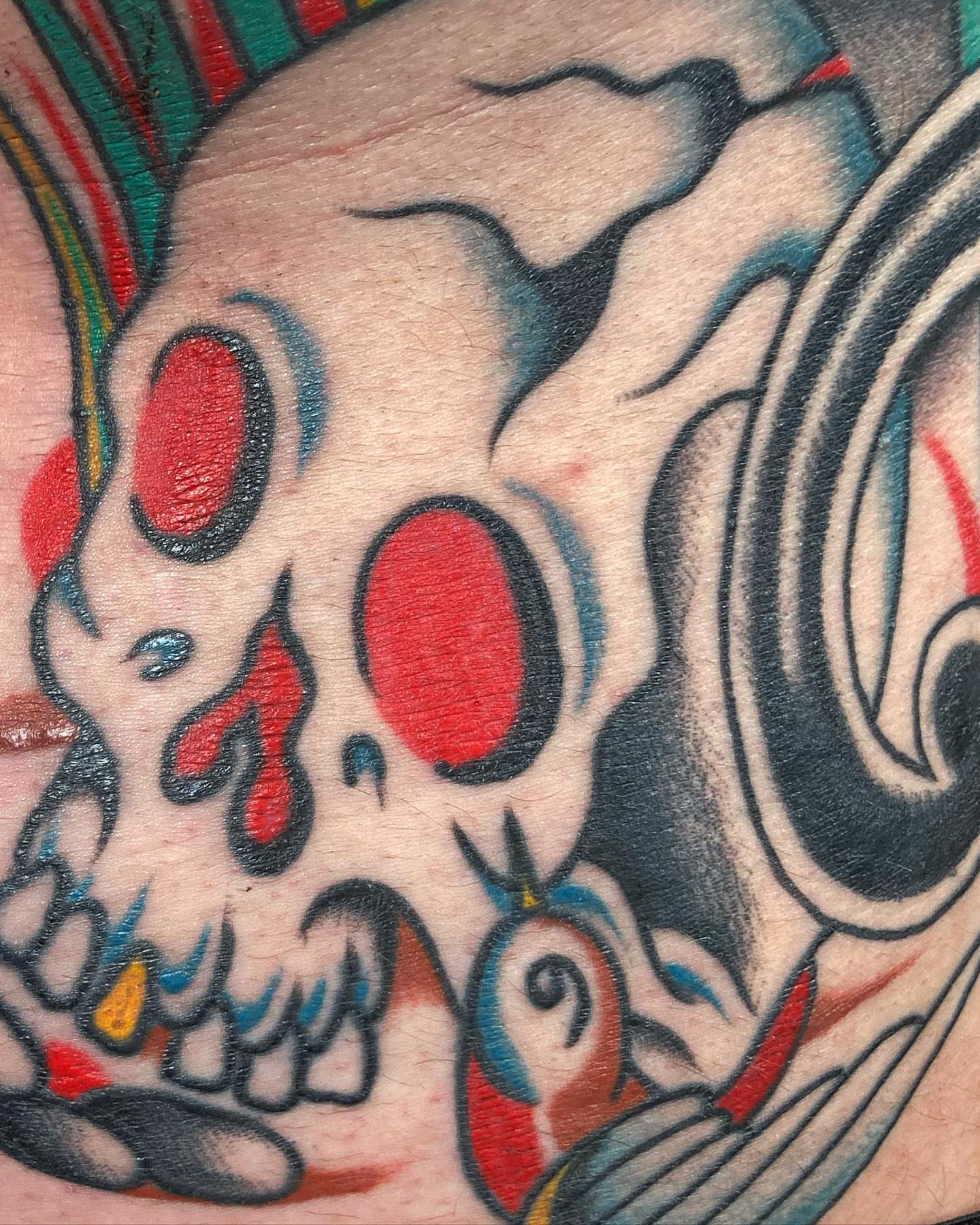 Skull with red eyes American traditional tattoo on the forearm by Rob Banks