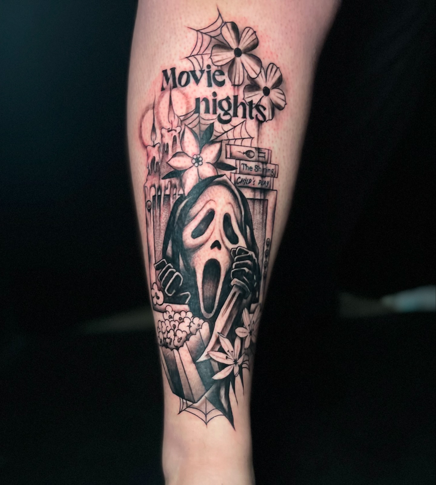 Movie nights black and grey tattoo on the forearm by Alex