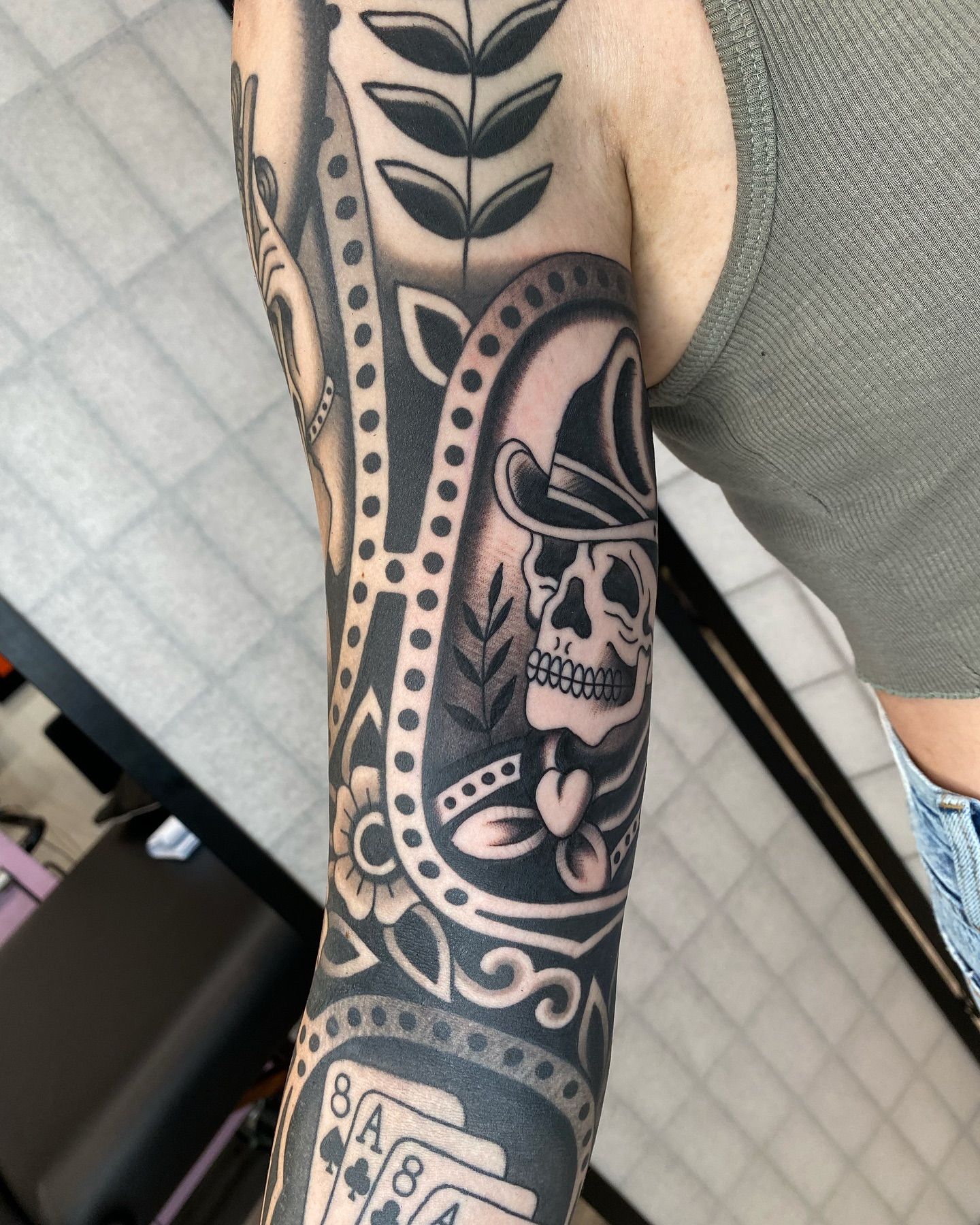 Skull and playing cards geometric tattoo on the forearm by Wes Hoffman