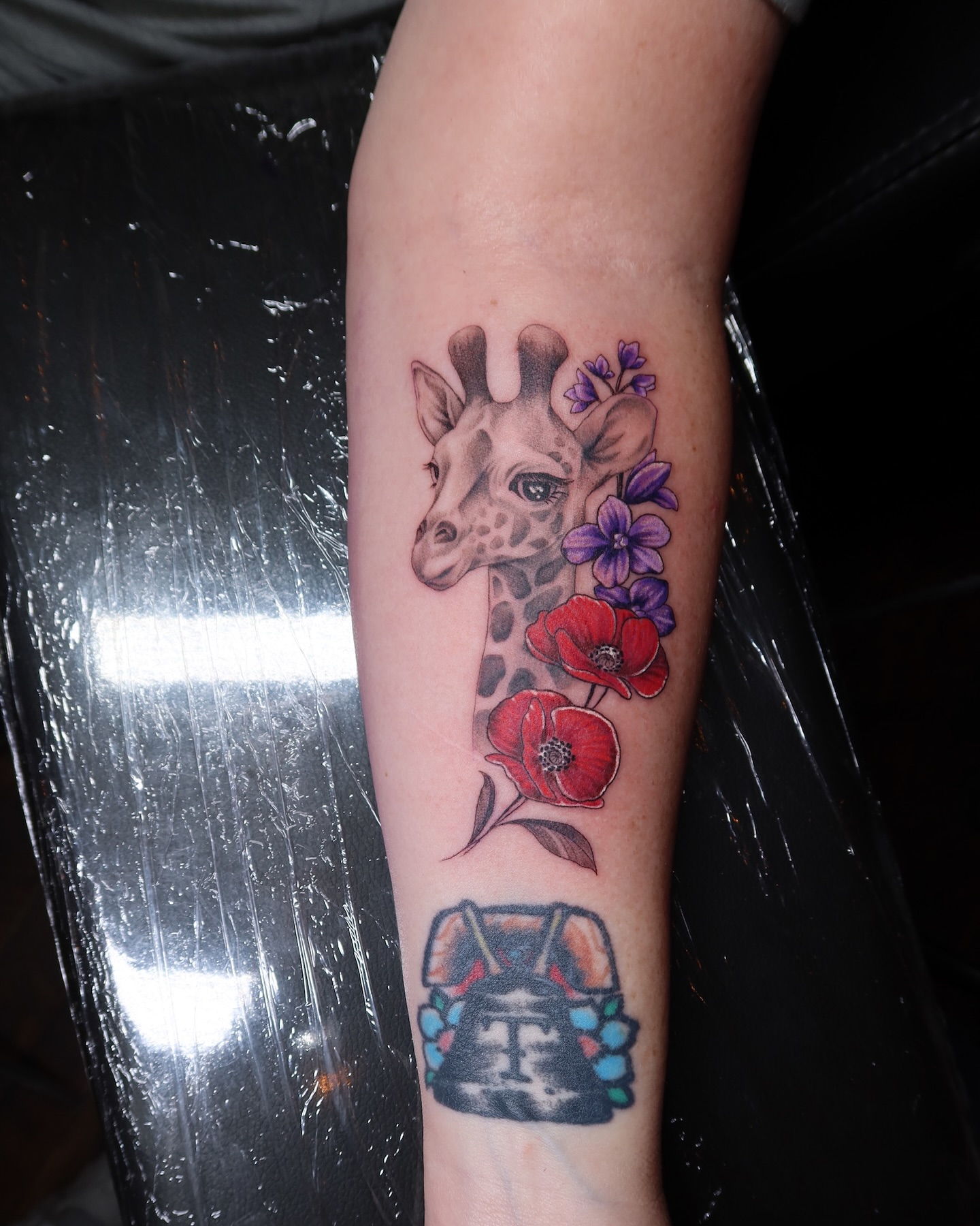 Giraffe and poppies realism tattoo on the forearm by Jevon Glasco Tattoos