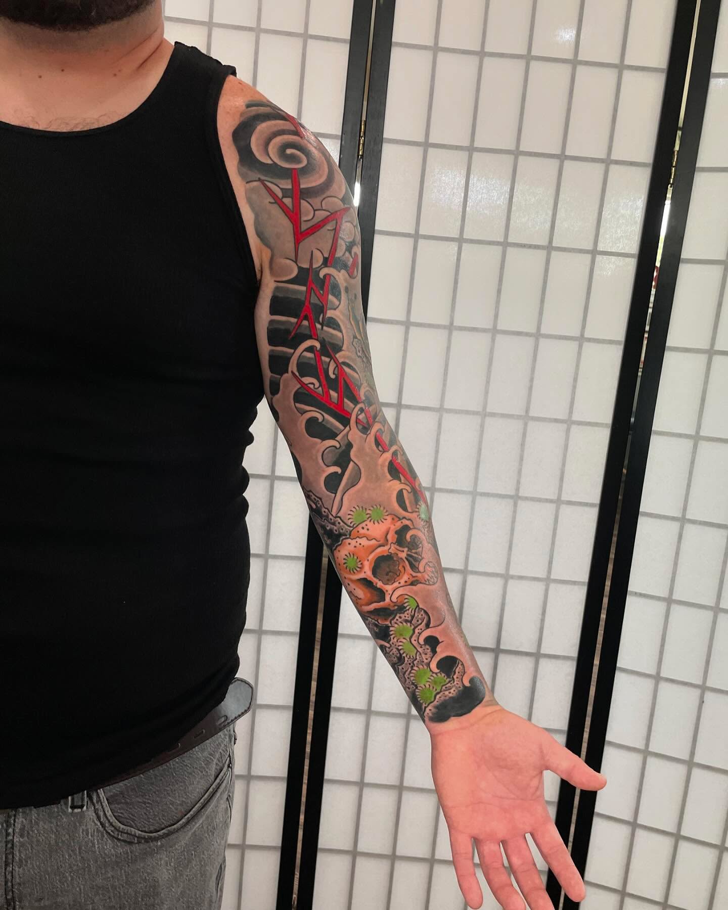 Spine with runes japanese irezumi tattoo on the upper arm by Caleb Baker