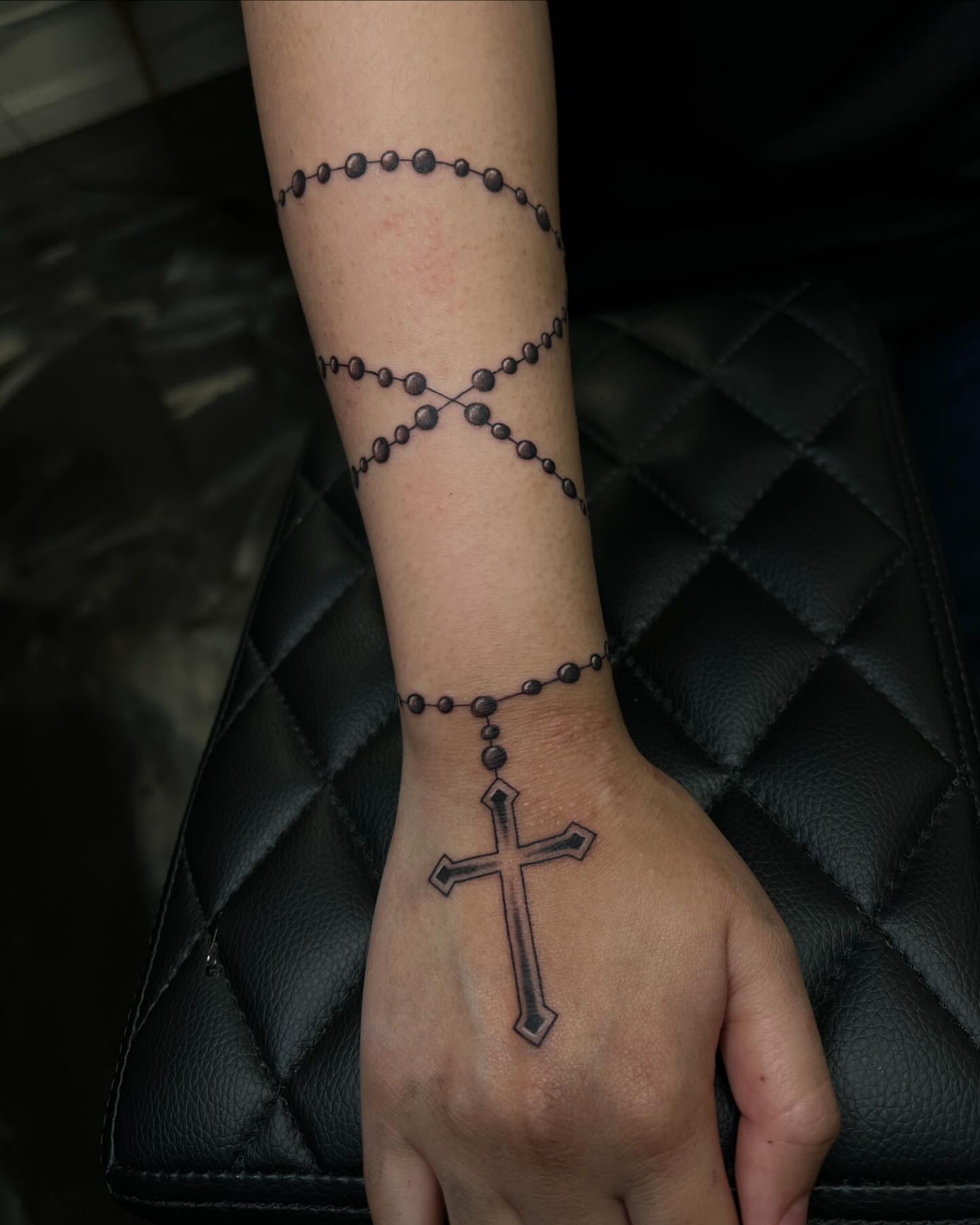 Rosary and cross black and grey tattoo on the forearm by San Diego Fineline Black & Grey Tattoo Artist