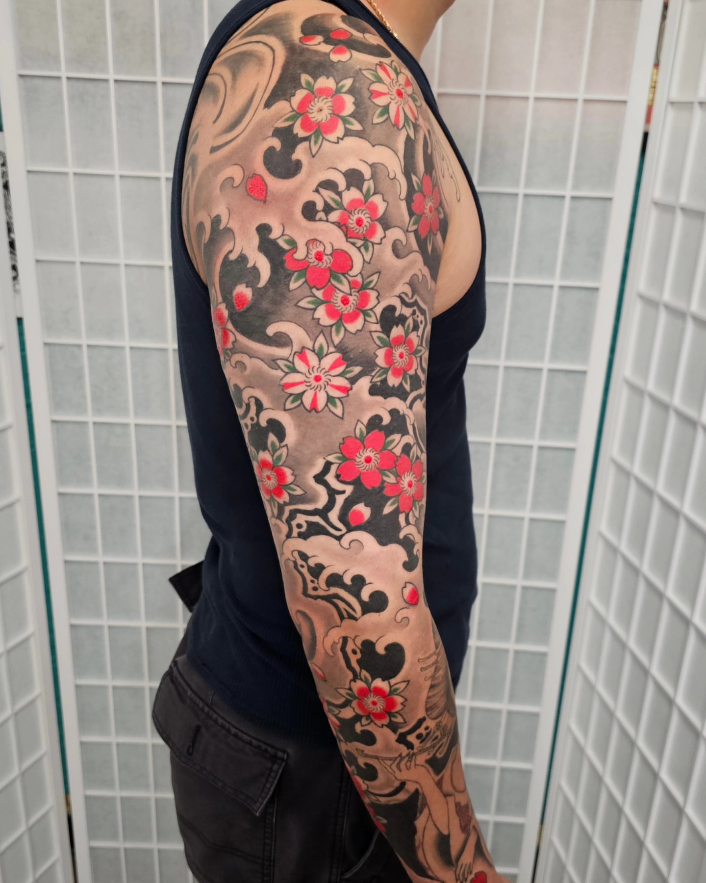 Cherry blossoms and waves japanese irezumi tattoo on the upper arm by Avelourd Legaspi