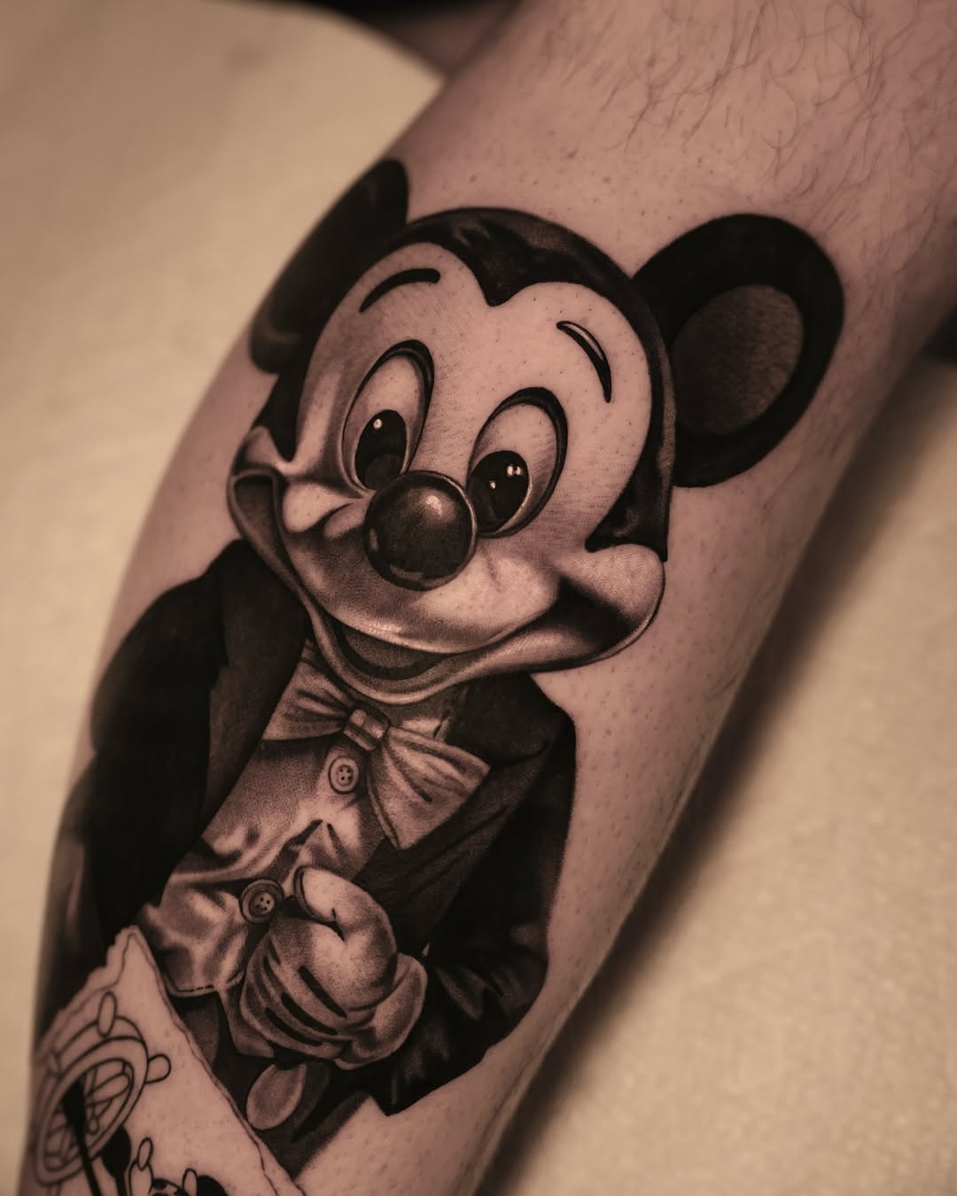 Mickey Mouse in a suit new school tattoo on the forearm by @kotytattoos