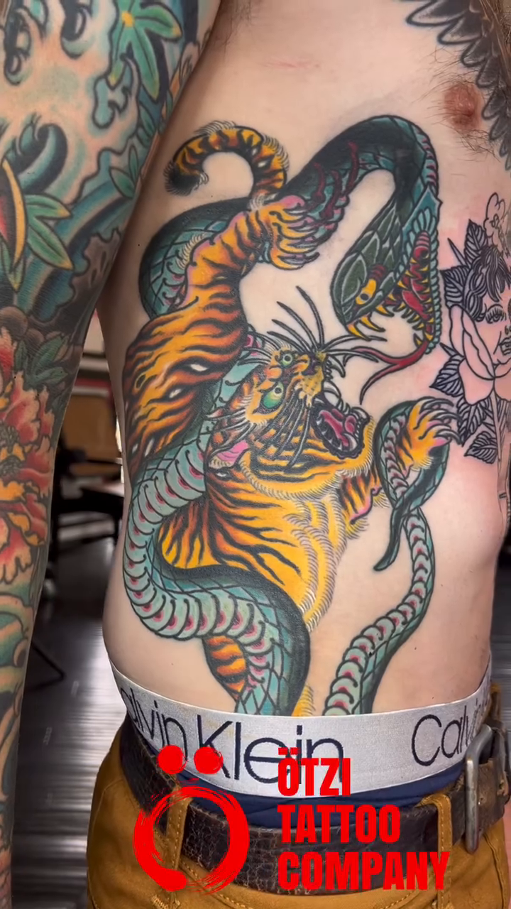 Tiger and snake fighting American traditional tattoo by Kayle Leogrande