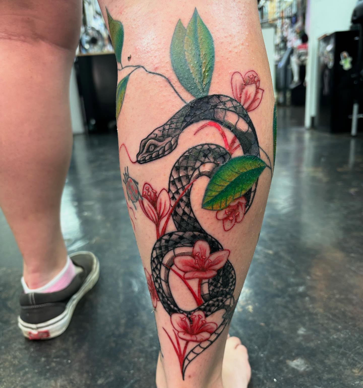 Snake and flowers American traditional tattoo on the calf by @seibastattoos, Virginia Beach, Virginia