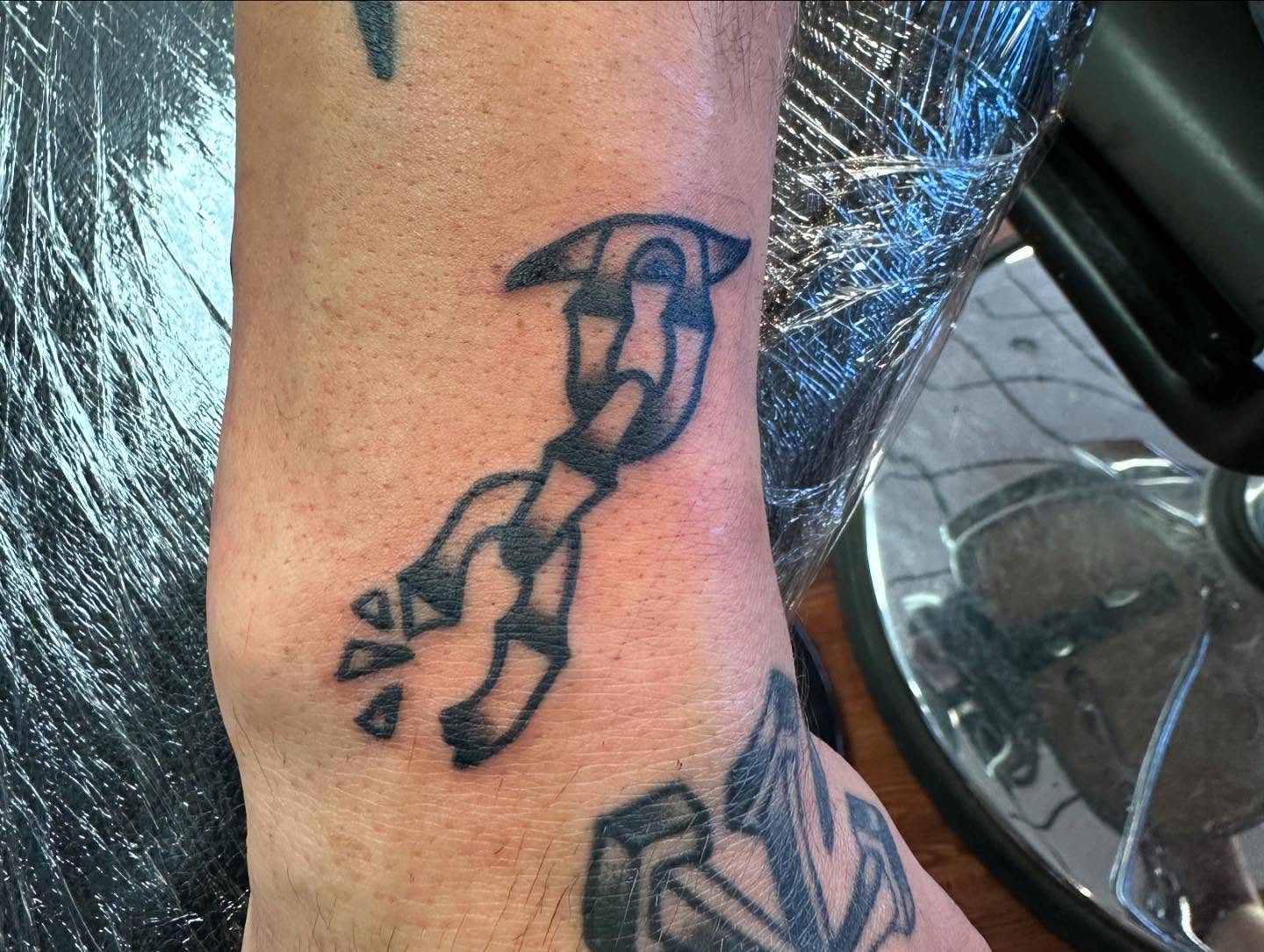 Broken chain black and grey tattoo on the forearm by Zach Eden