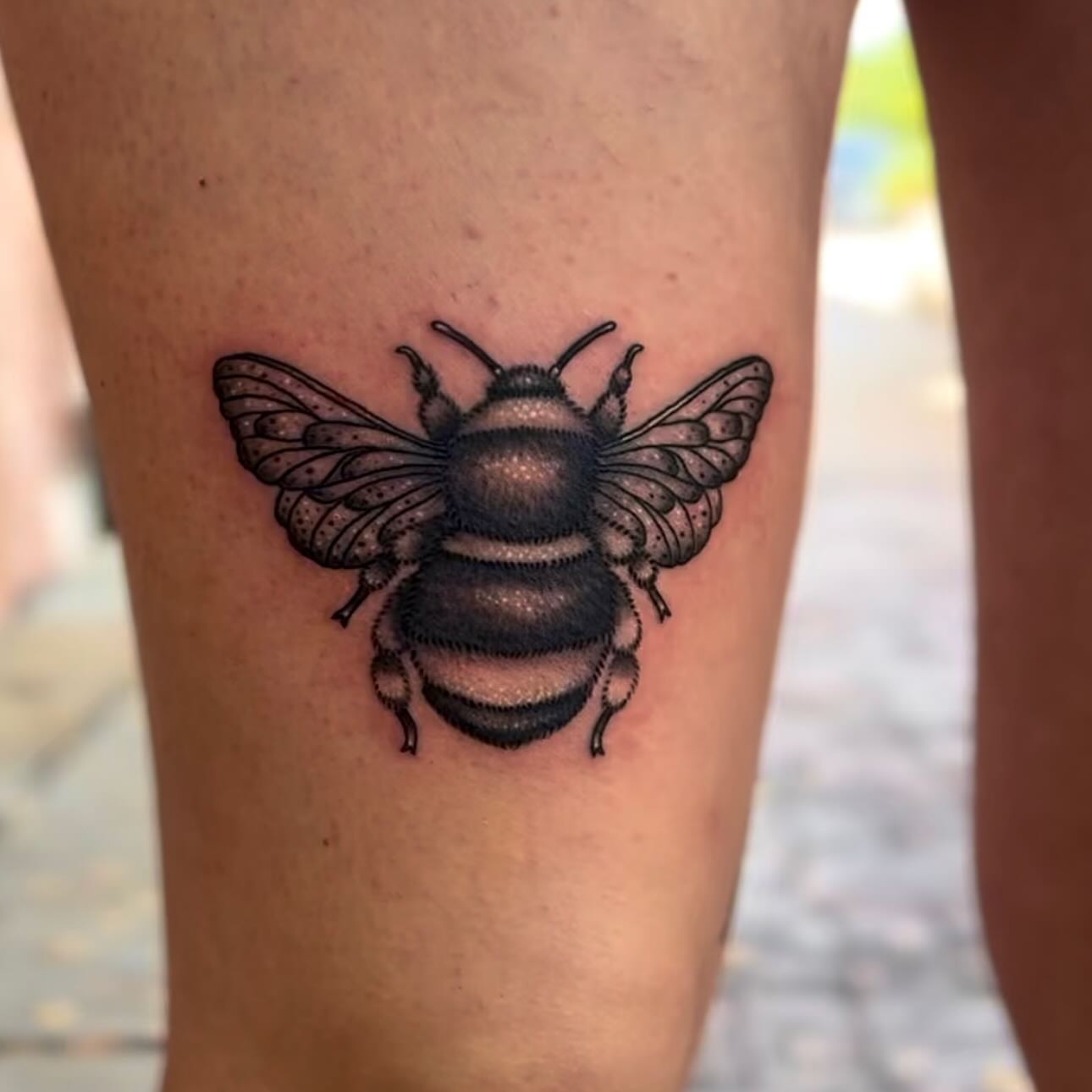 Bee black and grey tattoo on the thigh by Taylor Elizabeth 🕉️