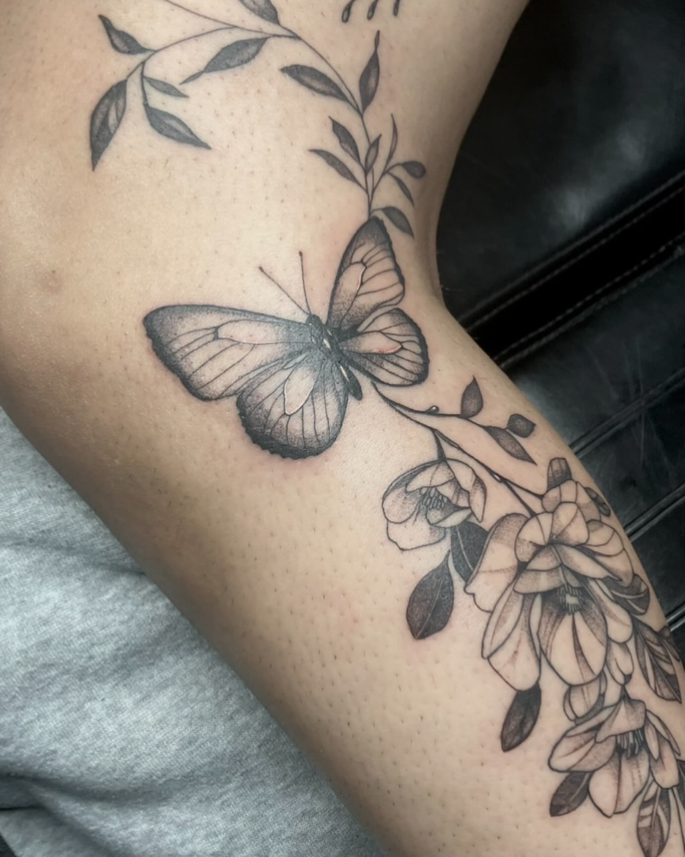 Butterfly and flowers realism tattoo on the forearm by V
