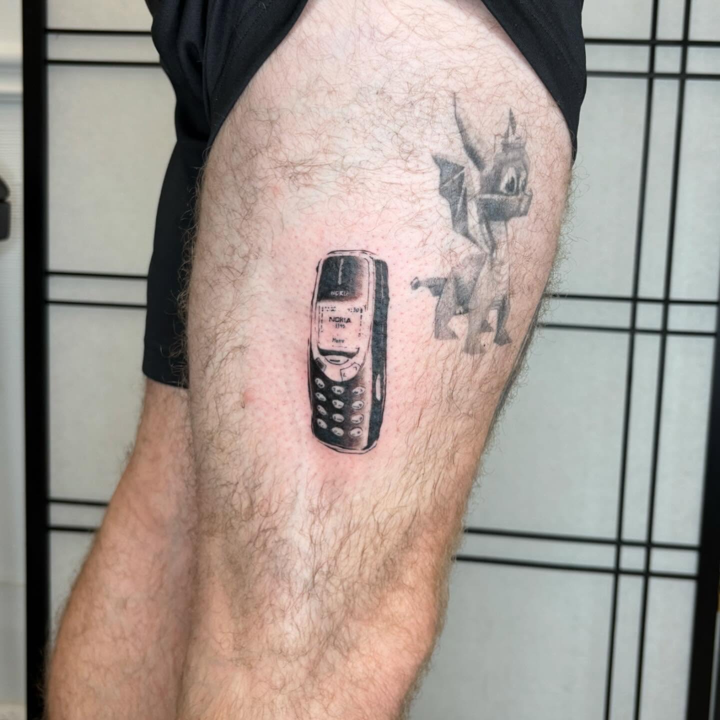 Cell phone realism tattoo on the thigh by sanjai