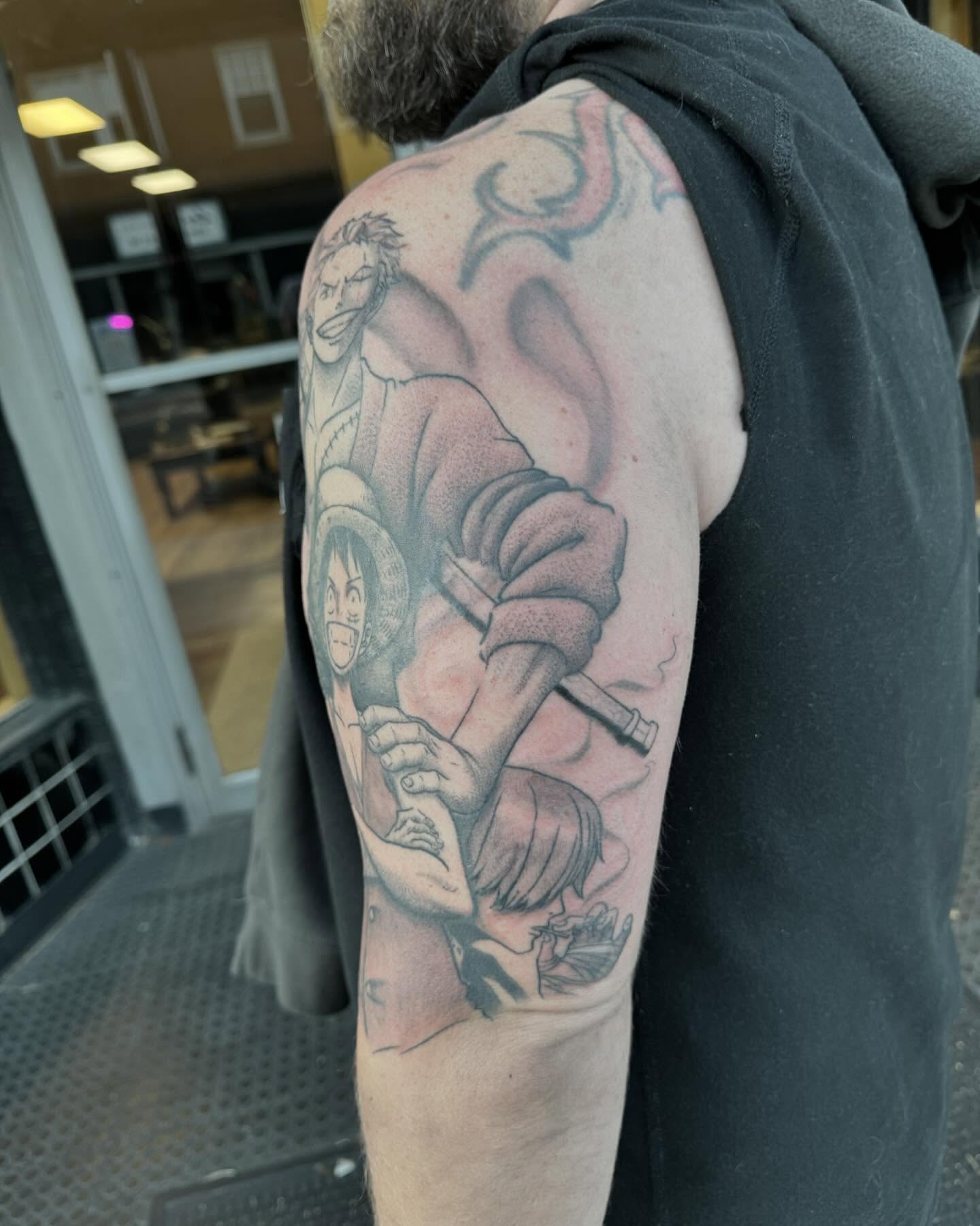 Anime characters dotwork tattoo on the upper arm by Kyle J. Bishop