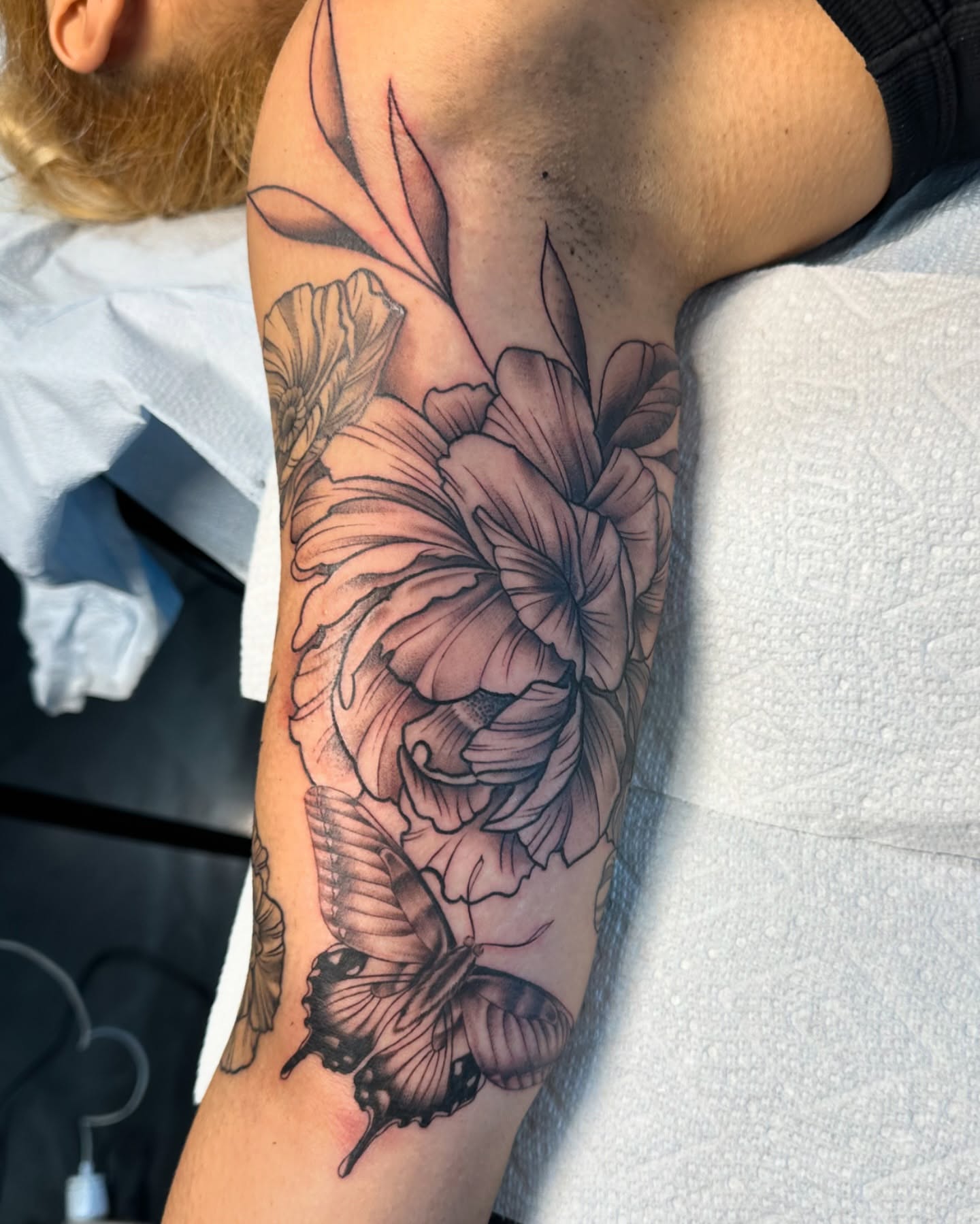 Flower and butterfly realism tattoo on the forearm by Dani B.