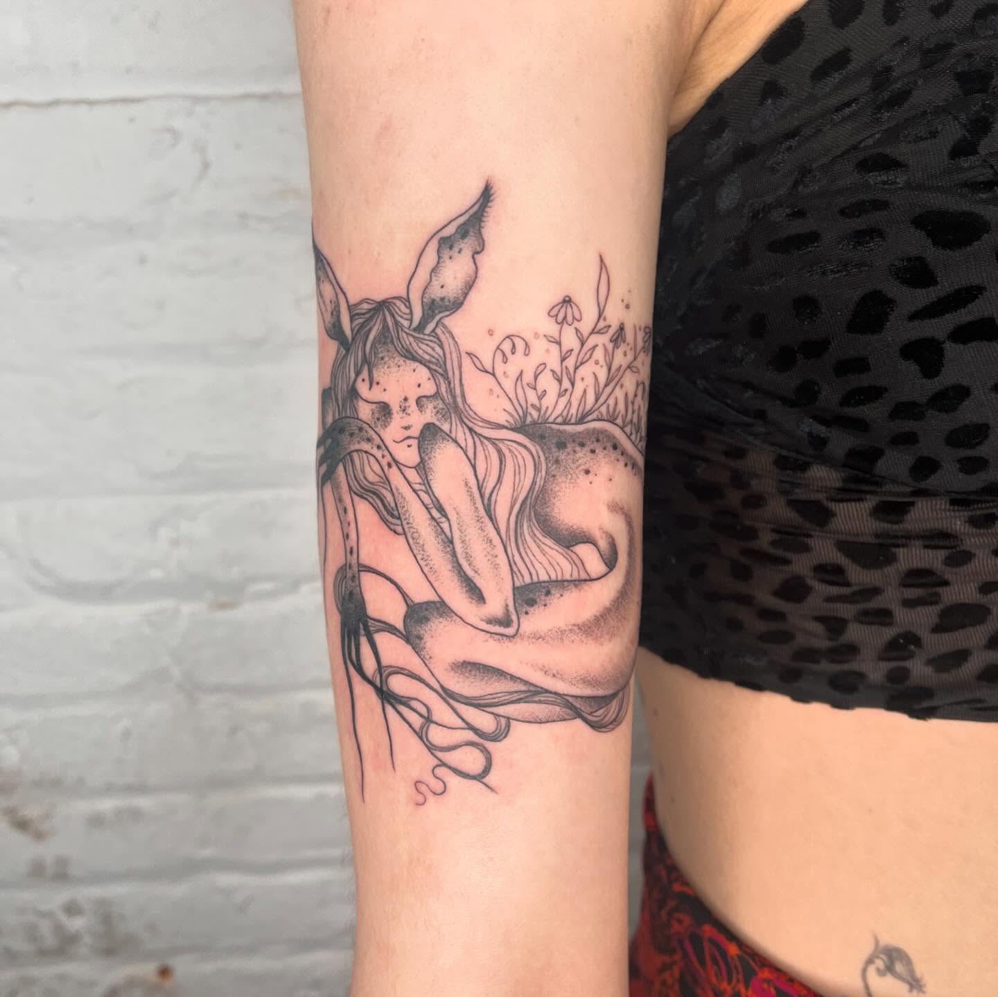 Woman with rabbit ears dotwork tattoo on the forearm by 𝔇𝔢𝔰𝔦