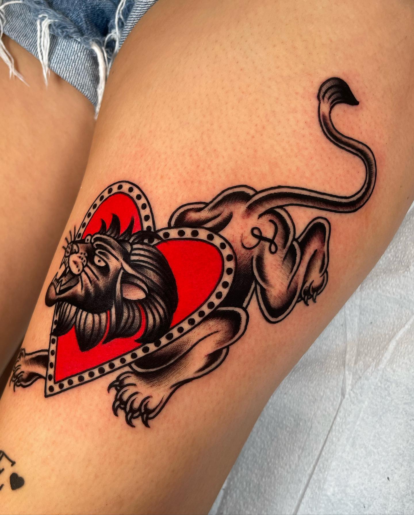 Lion and heart American traditional tattoo on the thigh by Jeff Miller philly traditional tattoo