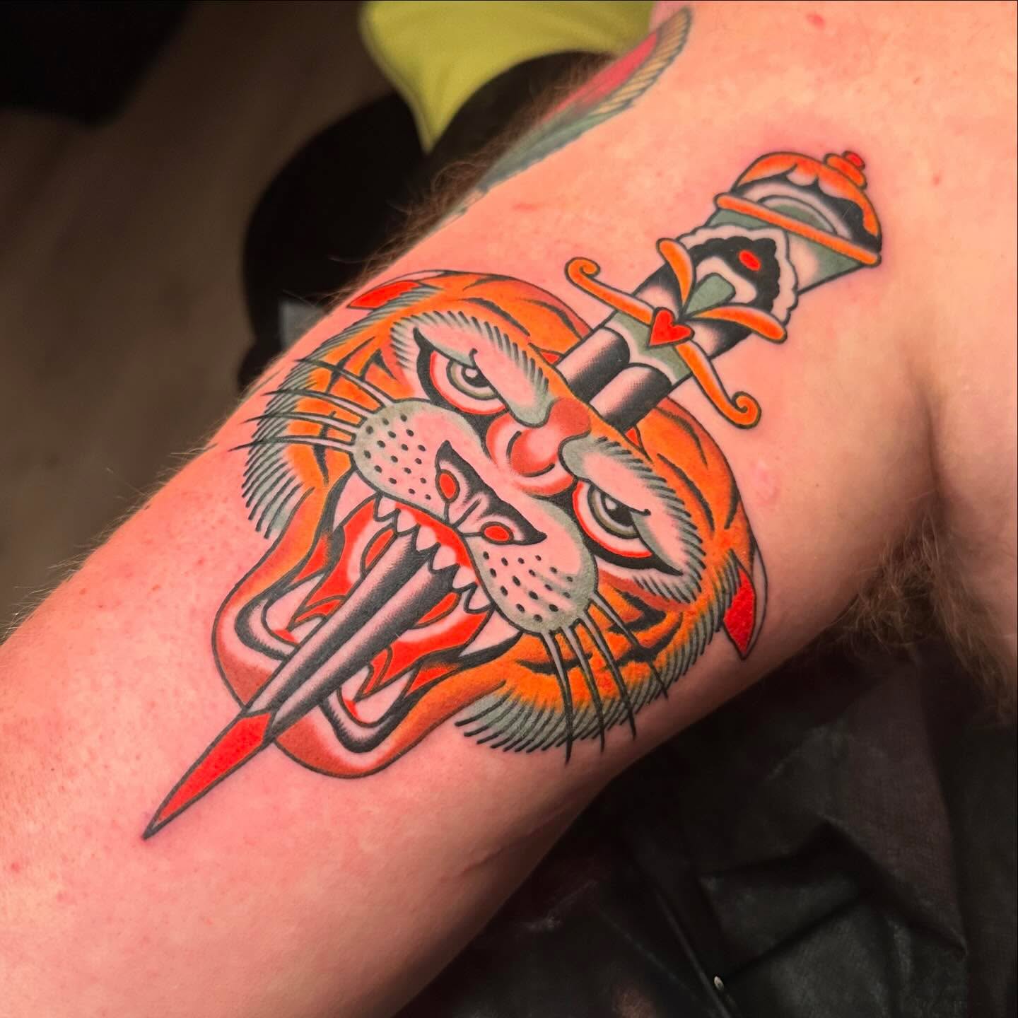Tiger head with dagger American traditional tattoo on the forearm by Chaz Otto