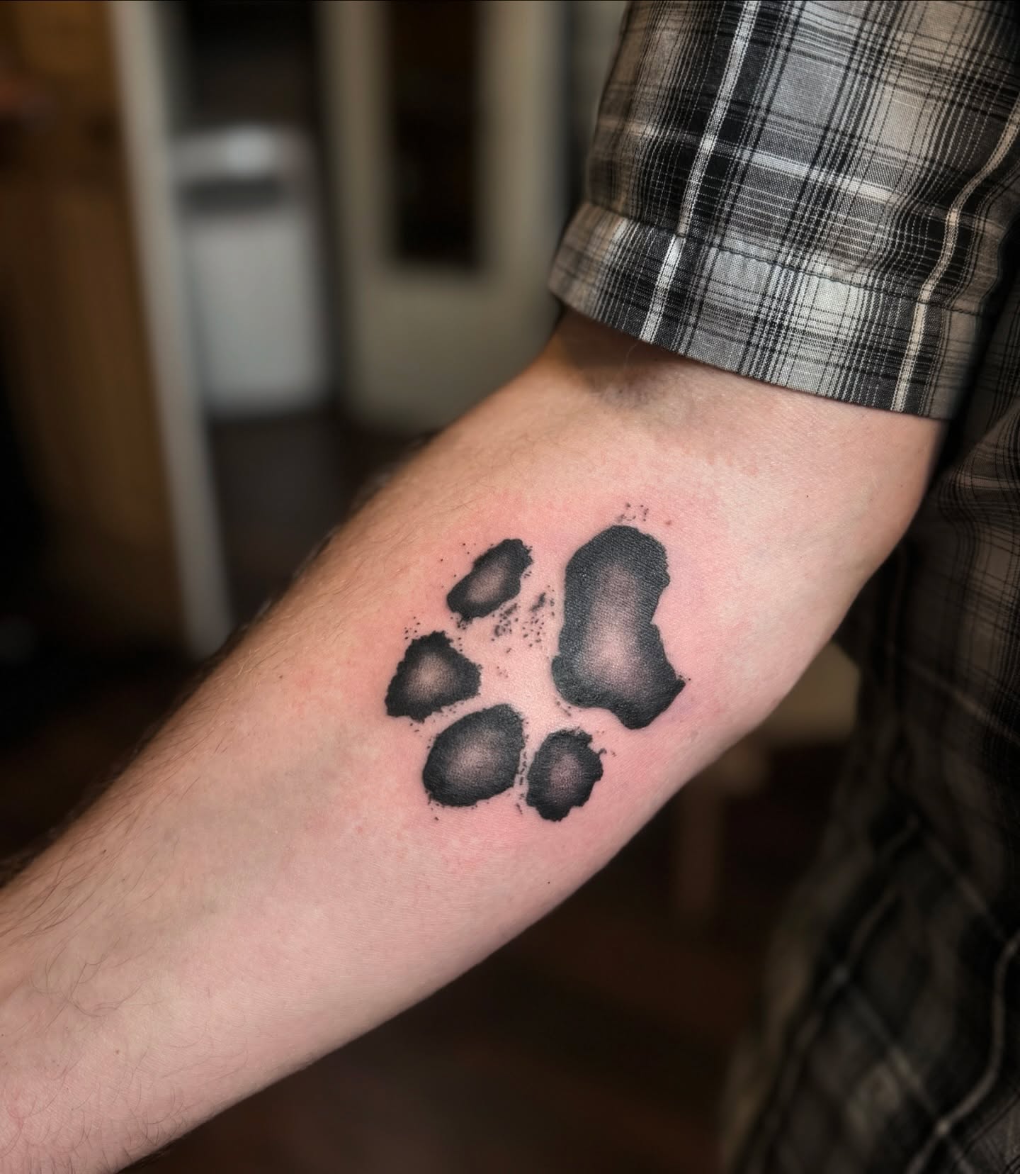 Paw print black and grey tattoo on the forearm by Mazie