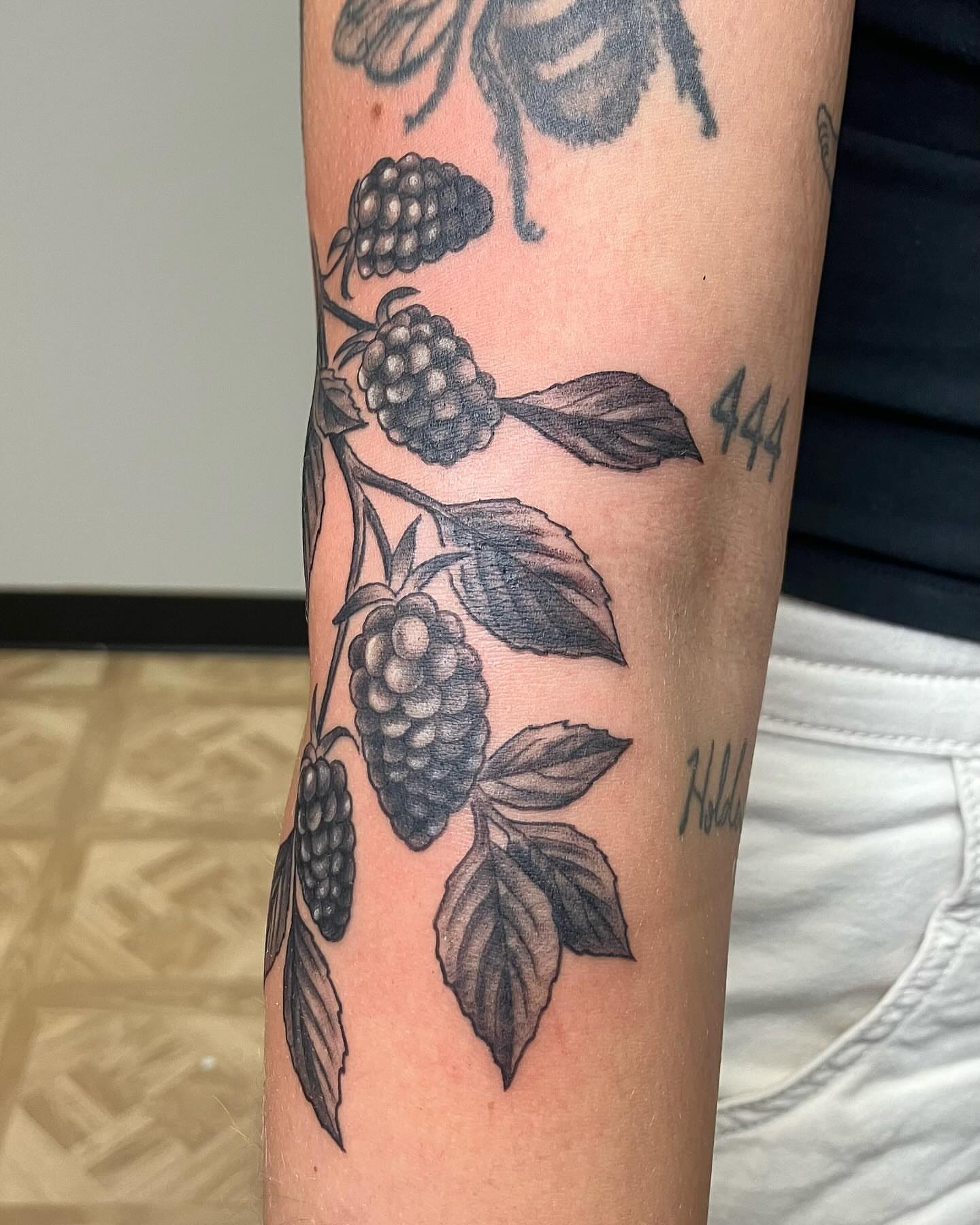 Blackberries black and grey tattoo on the forearm by Hunter McGinnis