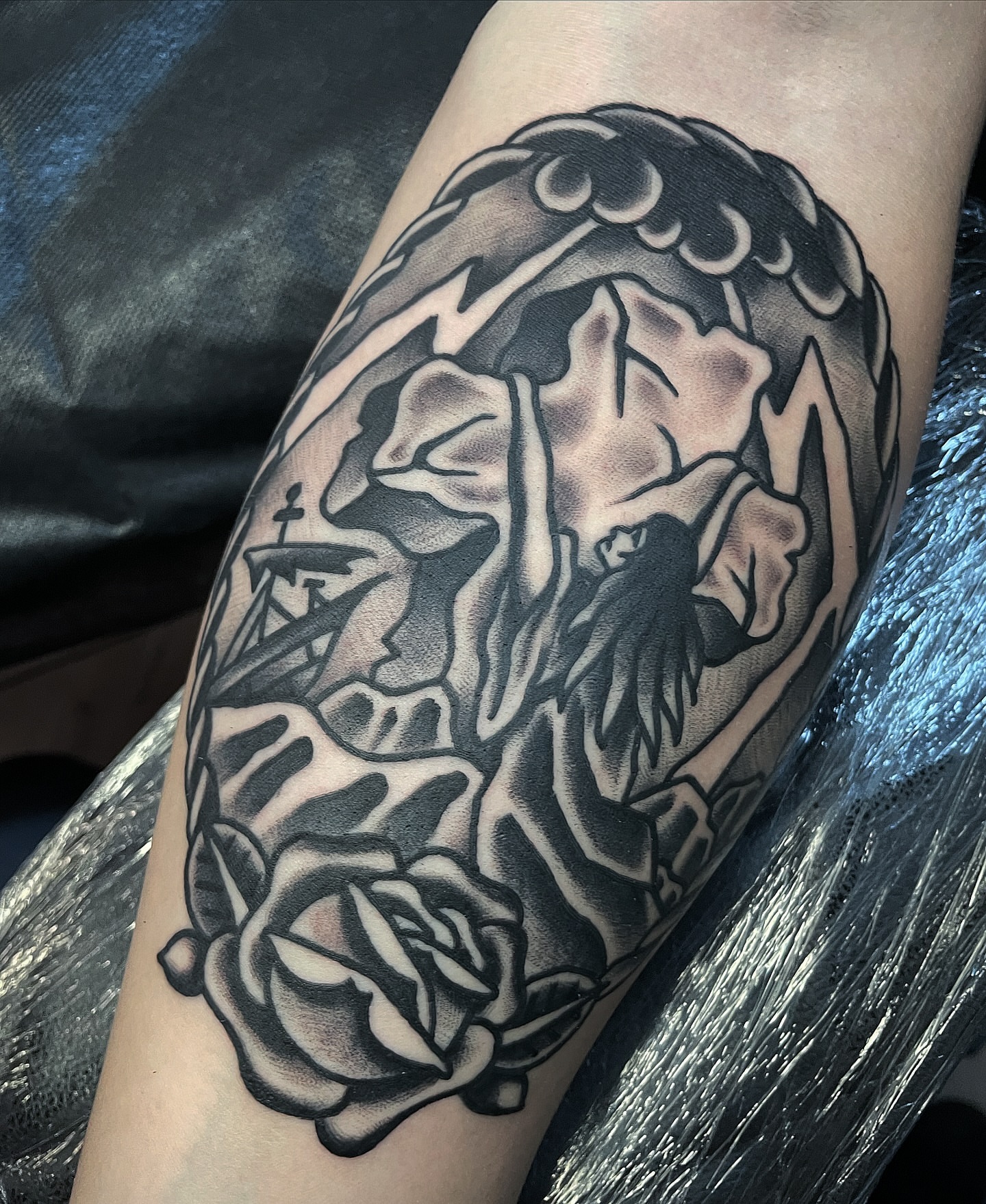Lion and roses American traditional tattoo on the forearm by Frank Mostek