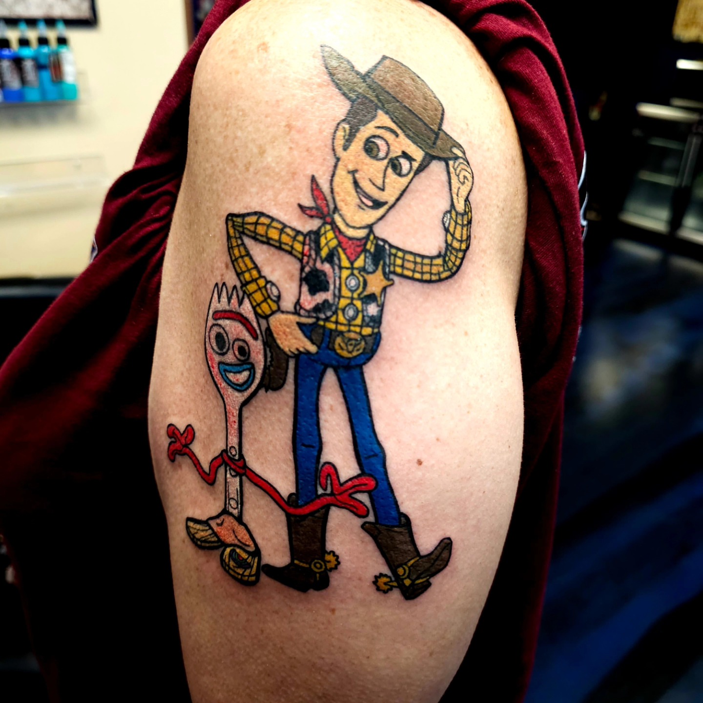 Woody and Forky illustrative tattoo on the shoulder by Germaine Sherman