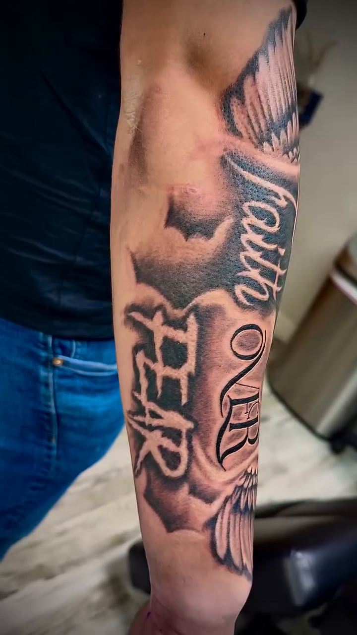Faith over Fear lettering with wings Chicano tattoo on the forearm by Luis Cabrera, Cleveland, Ohio