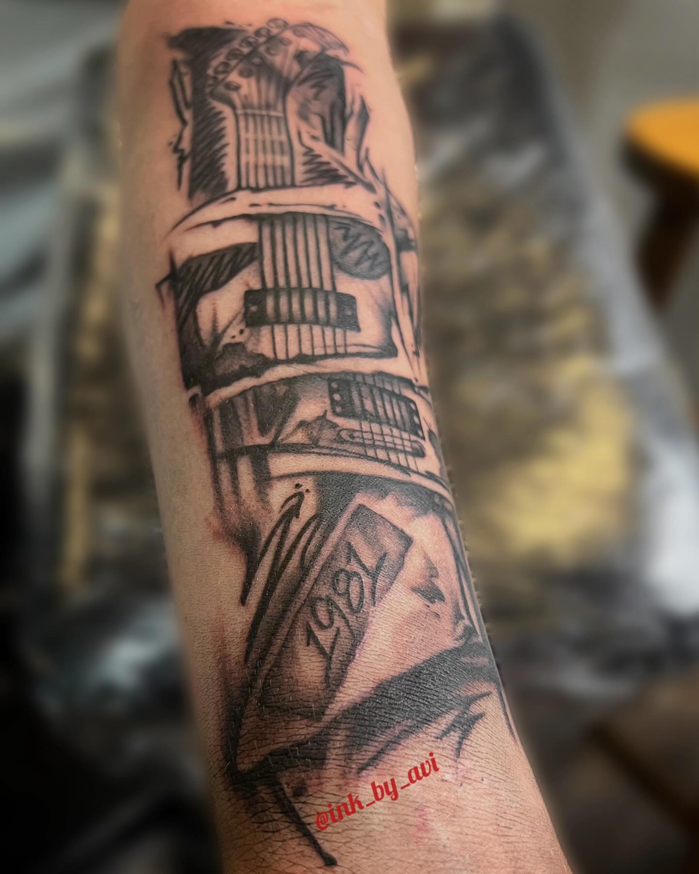 Guitar and book black and grey tattoo on the forearm by Avi, Cleveland, Ohio