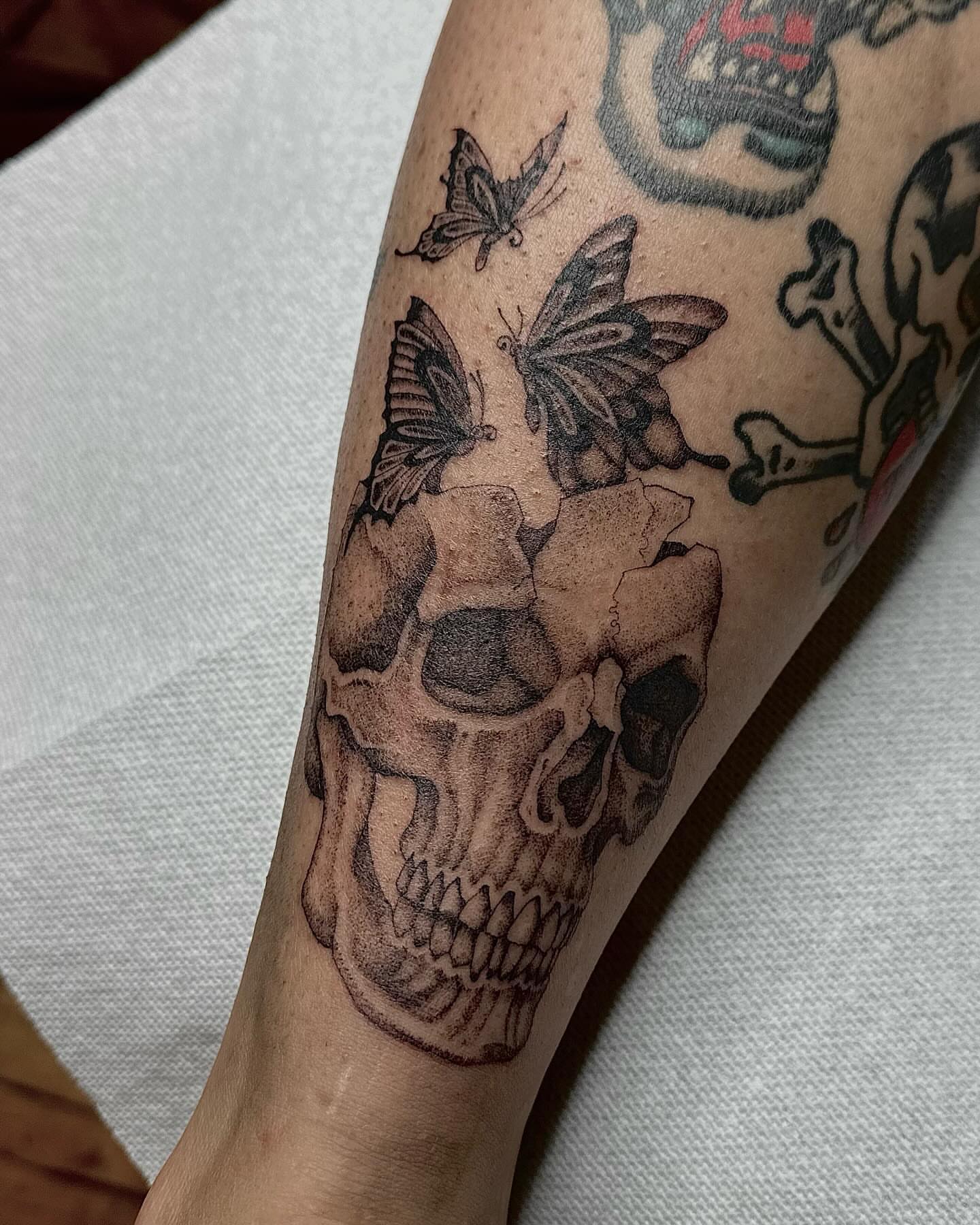 Skull with butterflies realism tattoo on the forearm by 𝖍𝖆𝖓𝖓𝖆𝖍