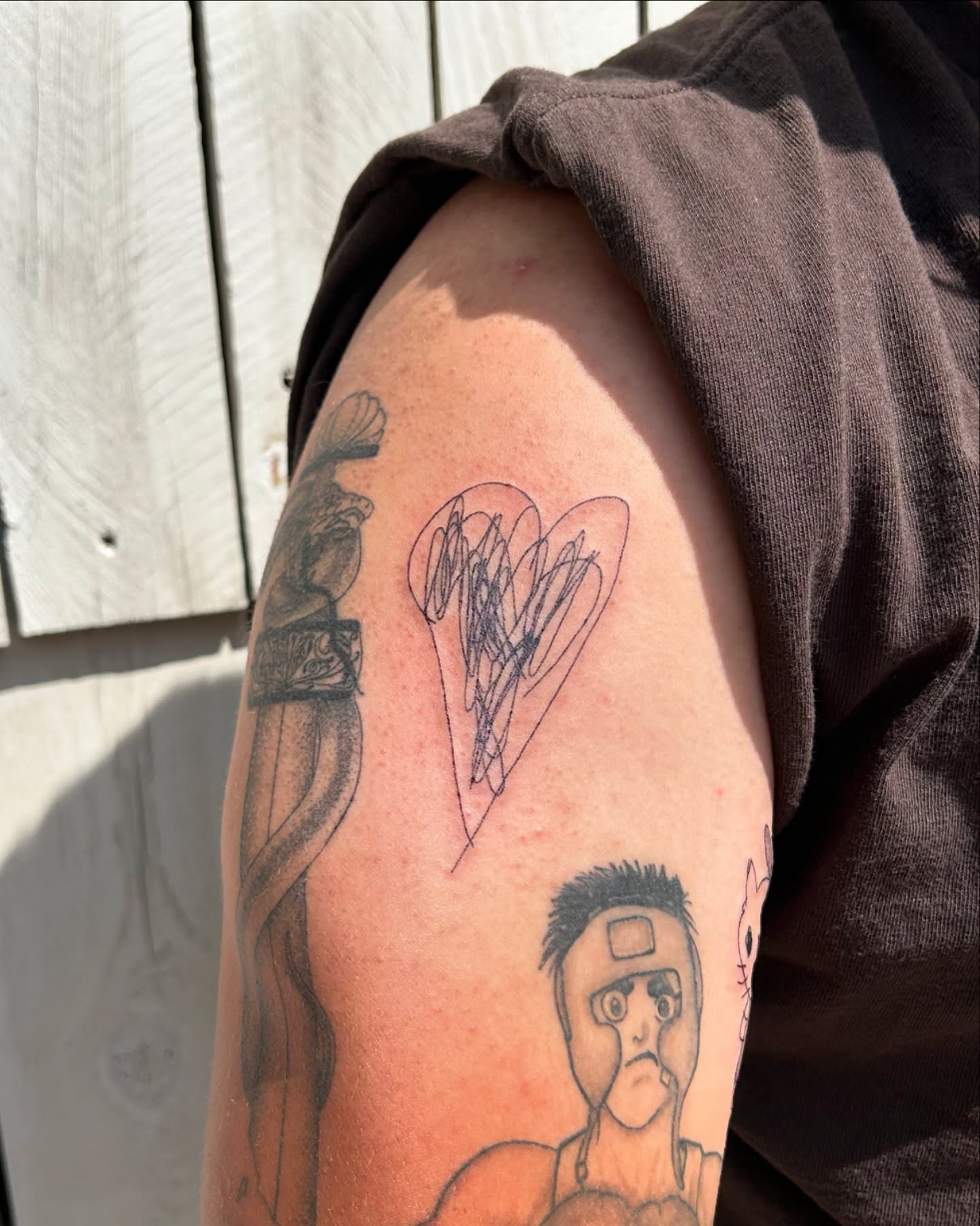 Heart black and grey tattoo on the upper arm by Kennedy Ramey