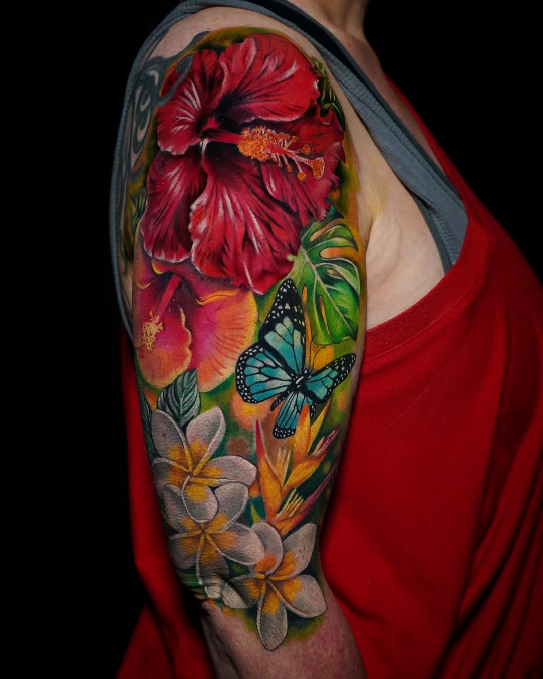 Hibiscus flowers and butterfly watercolor tattoo on the upper arm by Su Kang