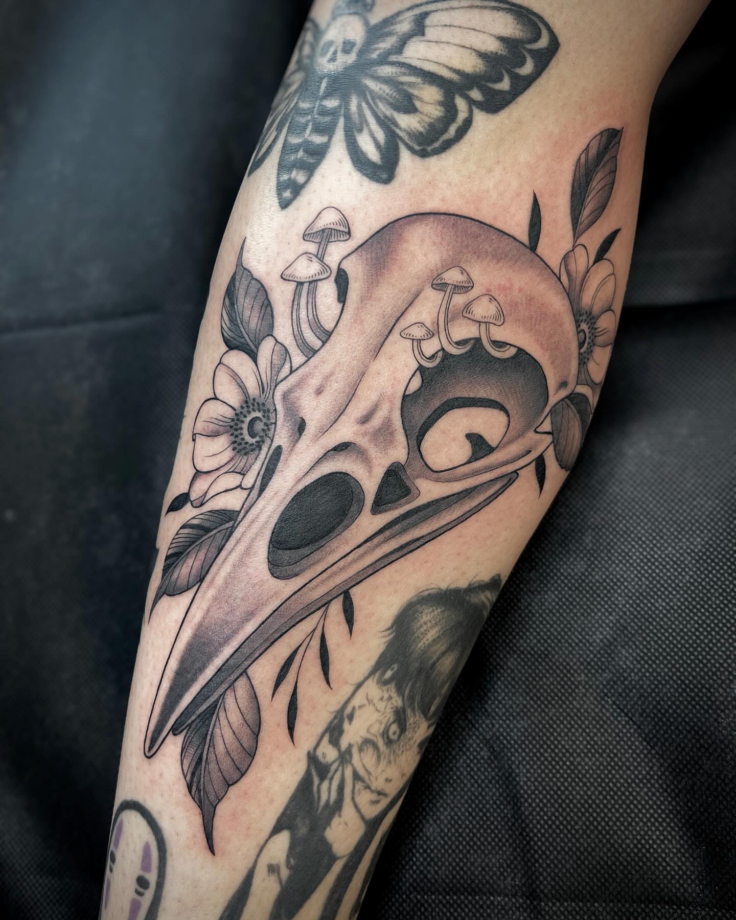 Bird skull and flowers realism tattoo on the forearm by Kelsi Steffensen