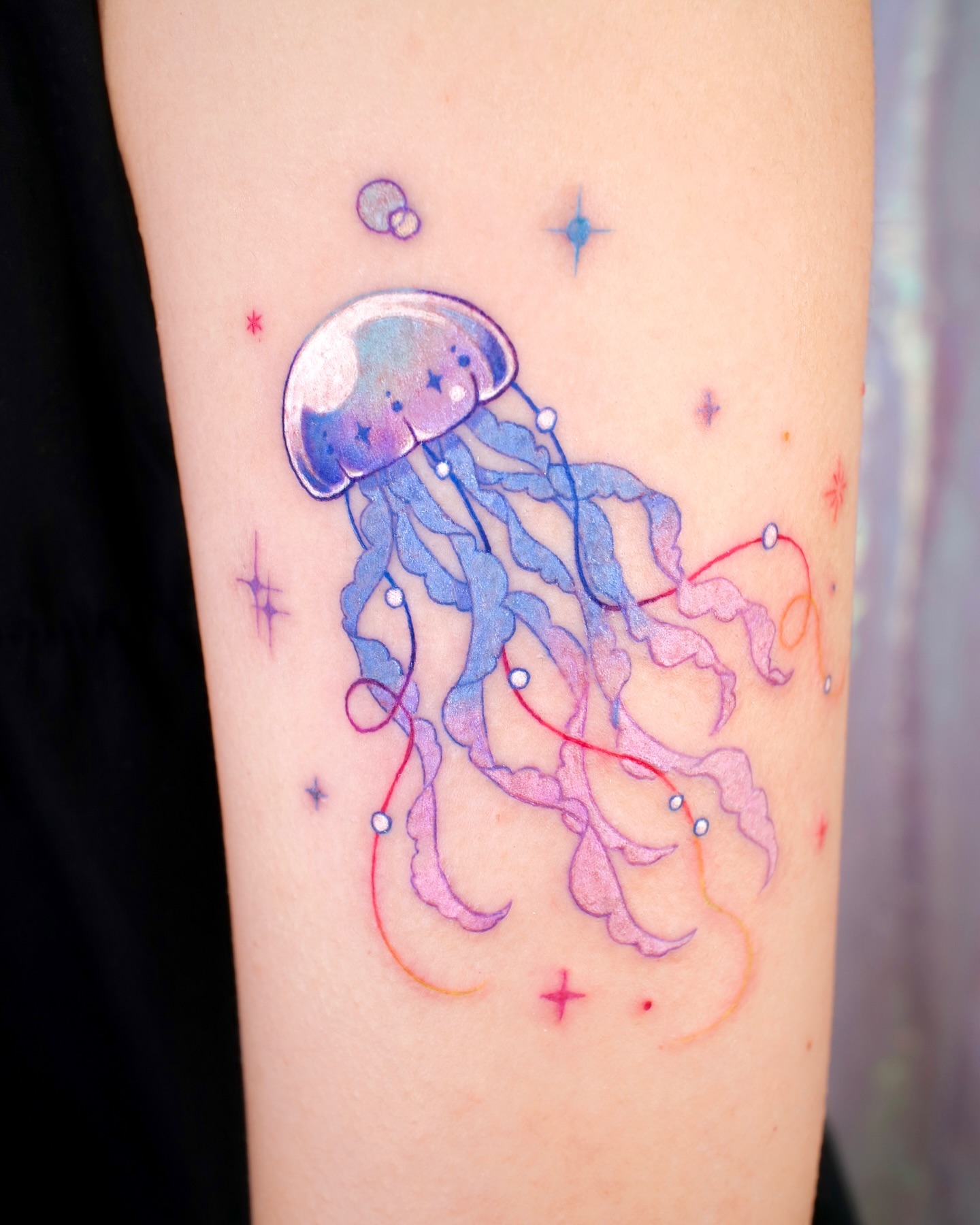 Jellyfish watercolor tattoo on the forearm by 밍꽈 타투