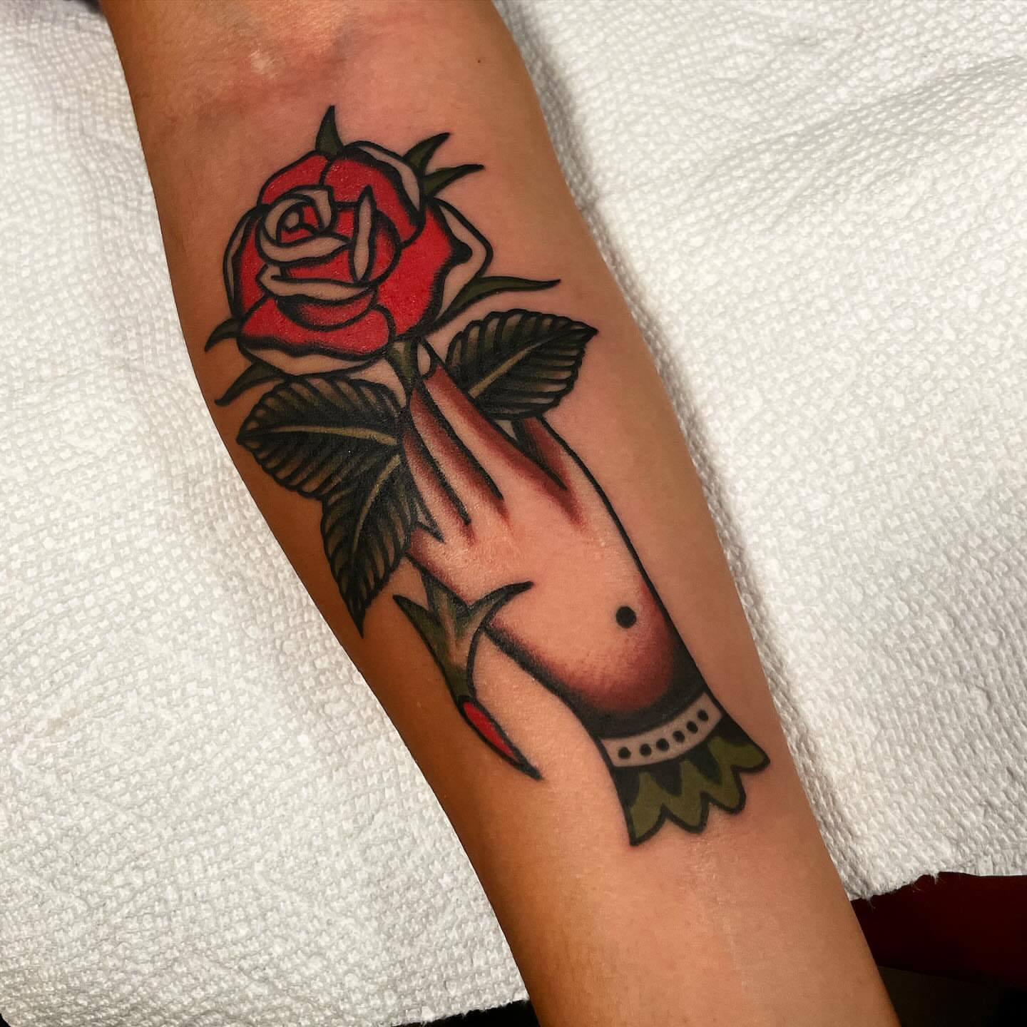 Rose and hand American traditional tattoo on the forearm by Mike Hudgins